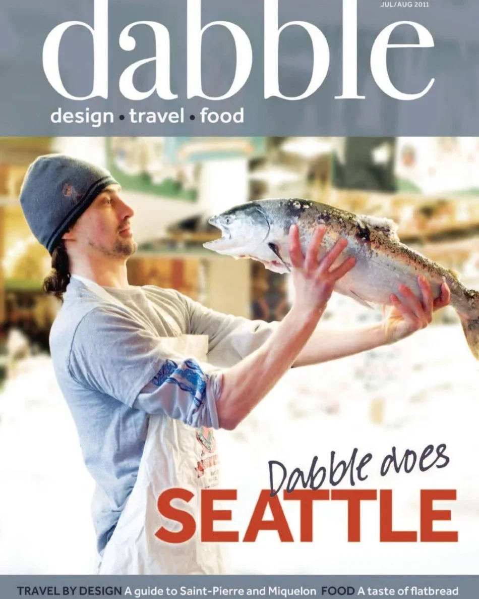 Cover of Dabble magazine, July/August 2011 issue, featuring a man in a beanie holding a large fish with a blurred market background, and text that reads 'Dabble does Seattle'.
