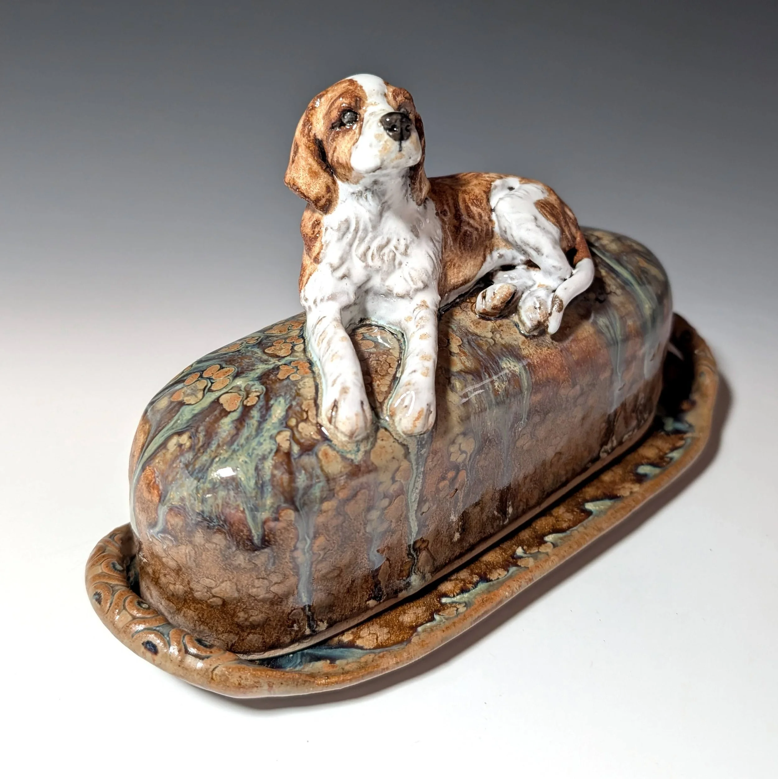 Custom made butter plate with lid. Lid has an original dog figurine laying on it.