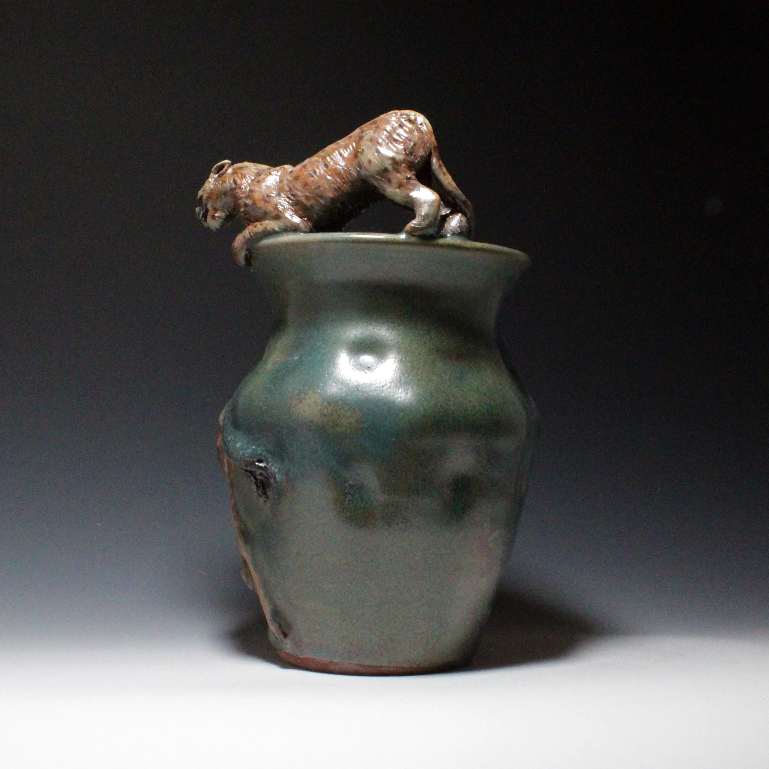 Spots can only be seen on one side of the cheetah due to the wood ash hiding spots on the inside edge of the vase rim much like this cheetah hid from its prey until the last moment before it attacks.  