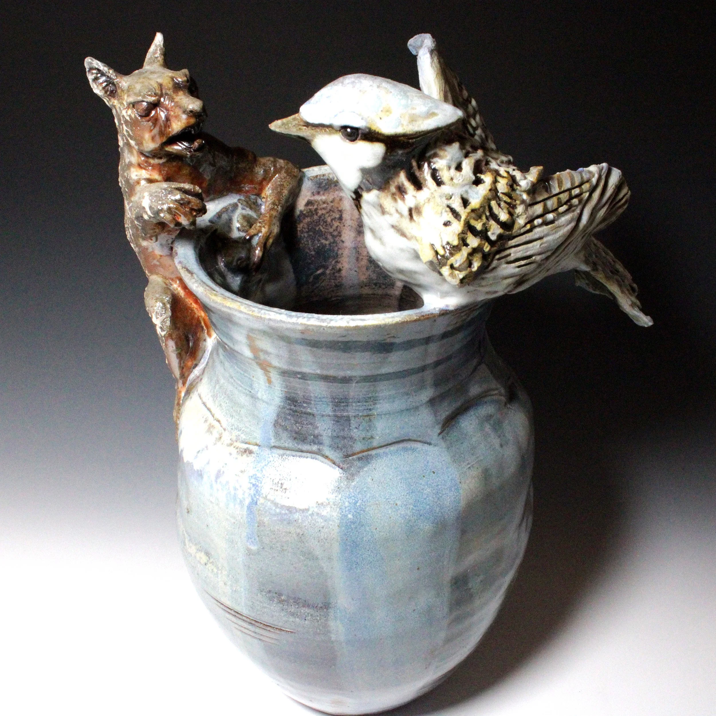 The glazes chosen for this piece have reduced or turned red toned as they face the inside of the pot due to removal of oxygen by starving the fire of air. This color change helps to heighten the feeling of aggression, a fight for food.