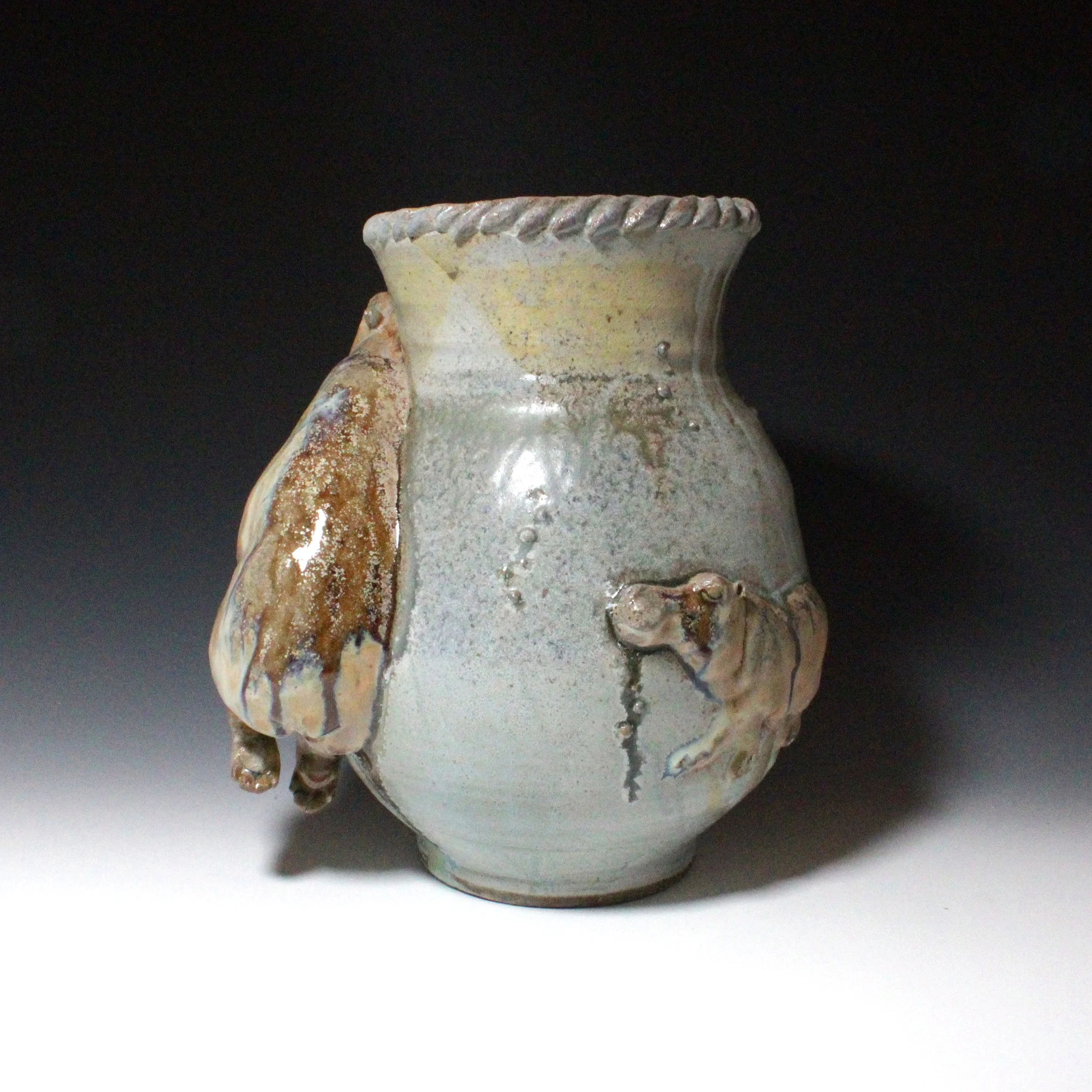 Wood ash glaze has created a steel blue metallic effect between the rump of the large mother hippo sculpture and a smaller hippo relief. 