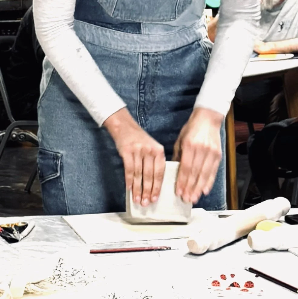 A student preparing clay during a school pottery class