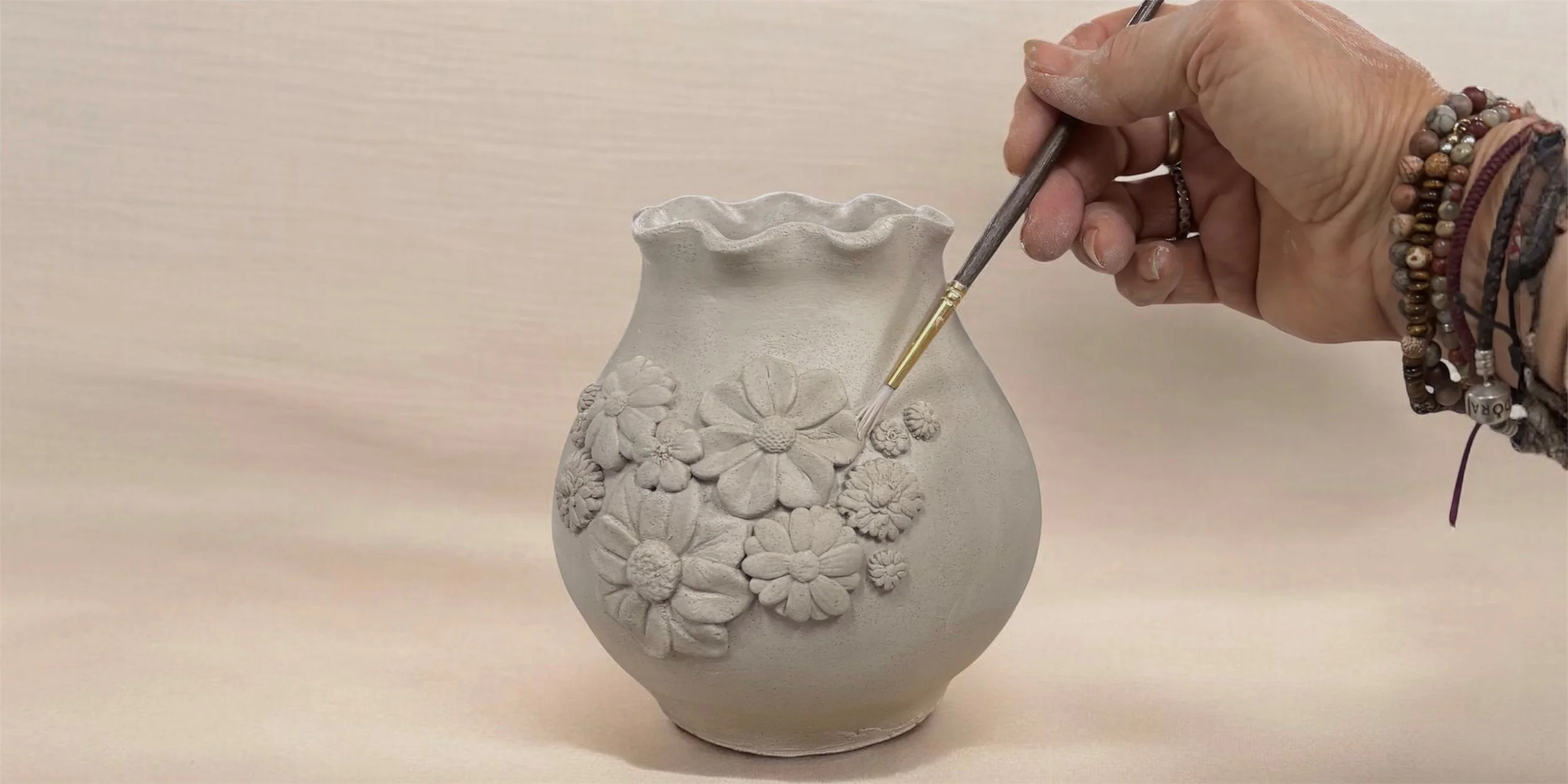 Handmade clay garden vase with delicate floral details created in The Garden Vase Workshop