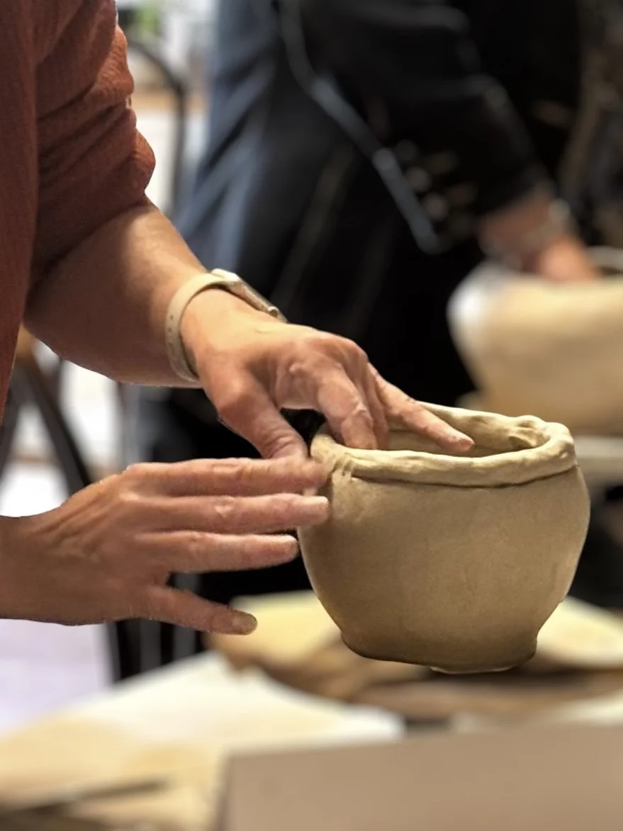 a student shaping a vase during a pottery workshop