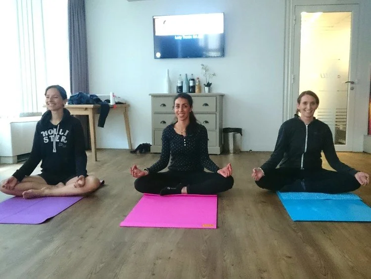 Employés pratiquant des postures de yoga au bureau à Toulouse, dans une séance adaptée à la gestion du stress professionnel.