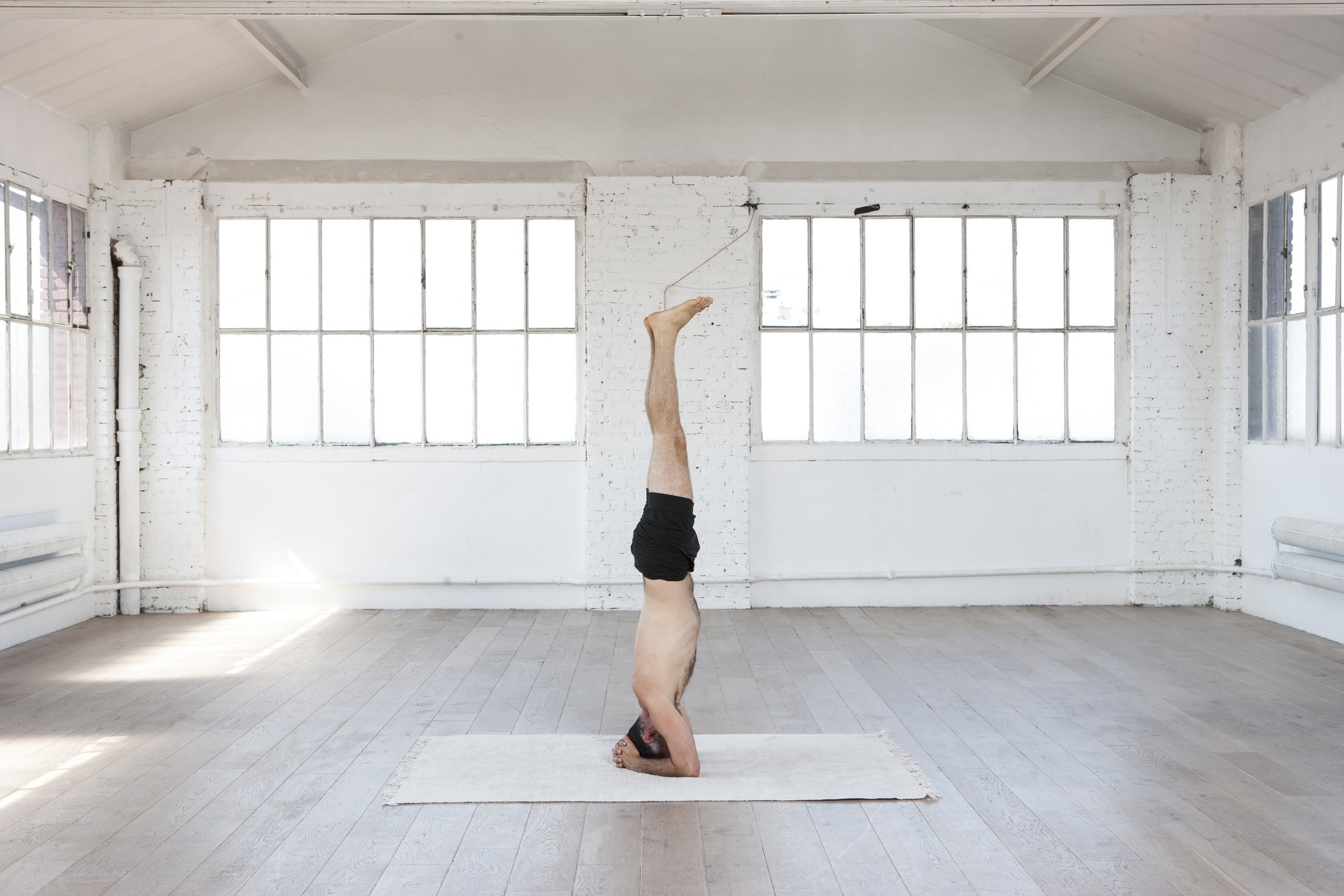 Pratique De La Belle Femme Yoga Près De Fond De Studio Fenêtre