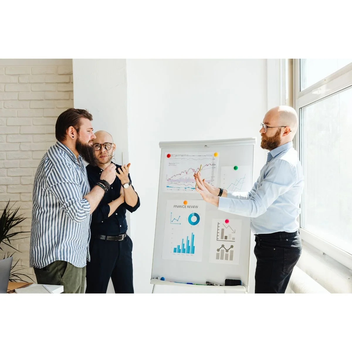Team discussing information in front of a dashboard display