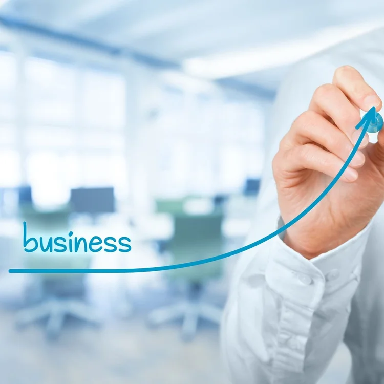 Business office background with a hand drawing an upward trend line with an arrow