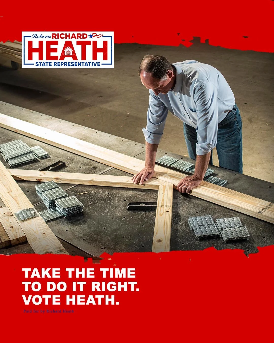 A man working with wooden beams and metal brackets, constructing a frame on a concrete floor, with campaign text urging to vote for Richard Heath for state representative, with a red background.