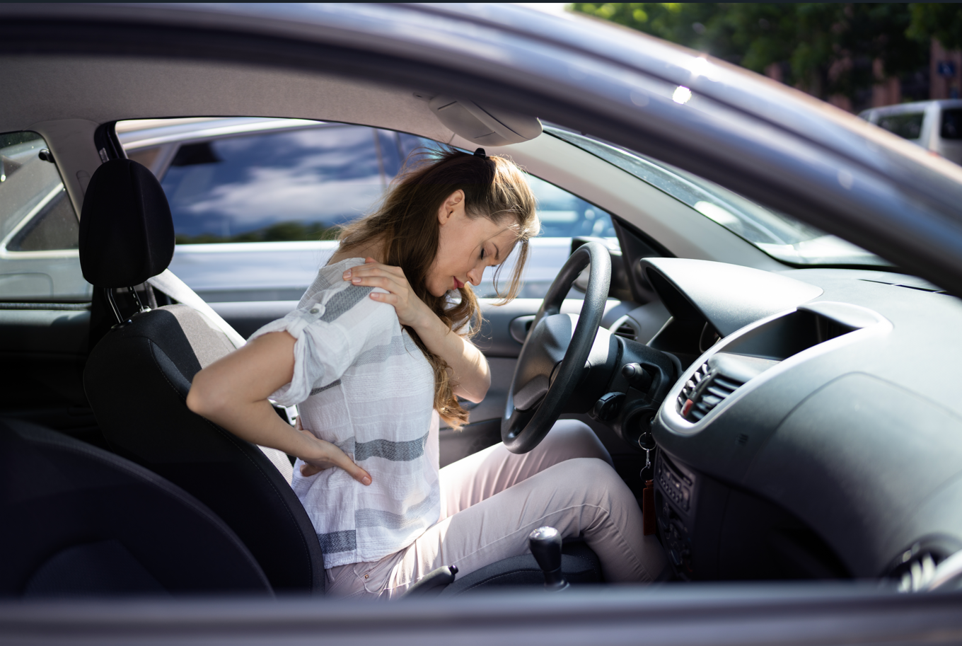 Woman experiencing neck and lower-back pain following a car accident