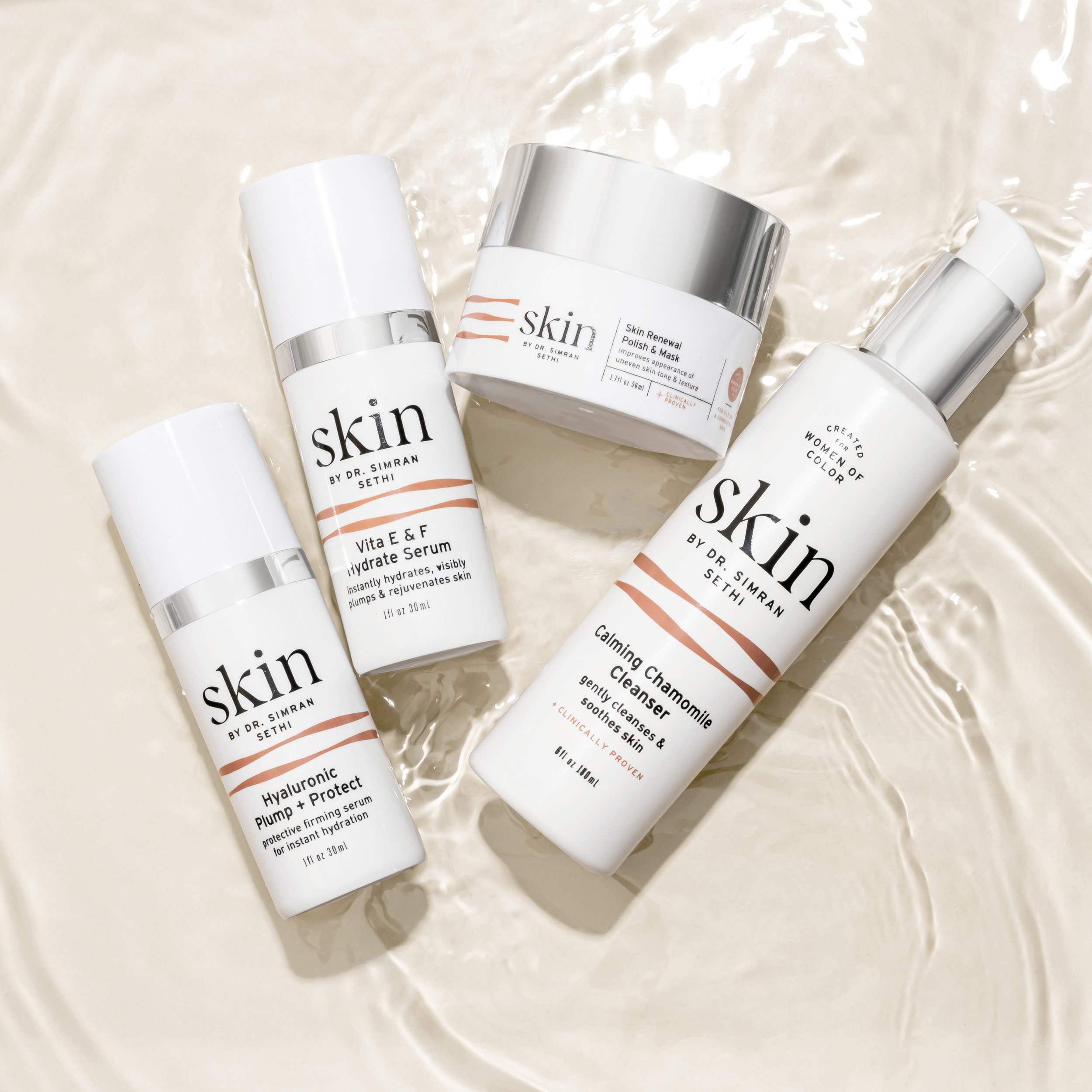 Collection of skincare products including a hydrating serum, calming chamomile cleanser, hyaluronic plump + protect serum, and skin renewal polish & mask on a water surface.