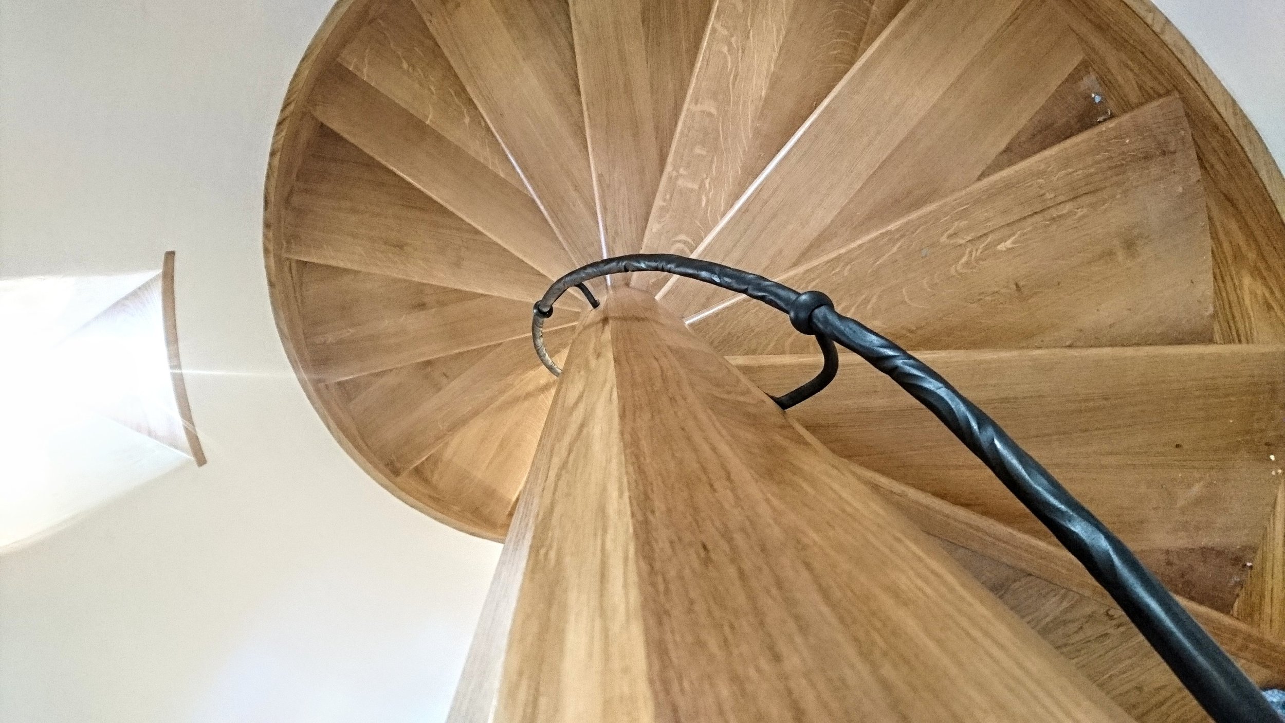 AD Designs hand forged bespoke spiral staircase handrail on oak staircase with water twist texture