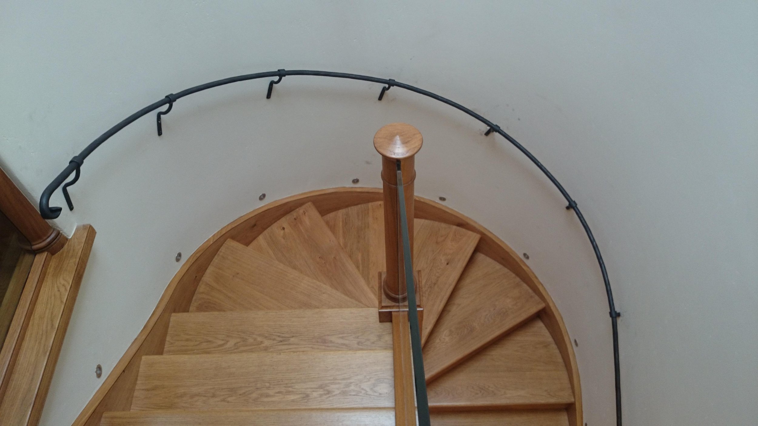 AD Designs hand forged bespoke curved staircase handrail with oak staircase