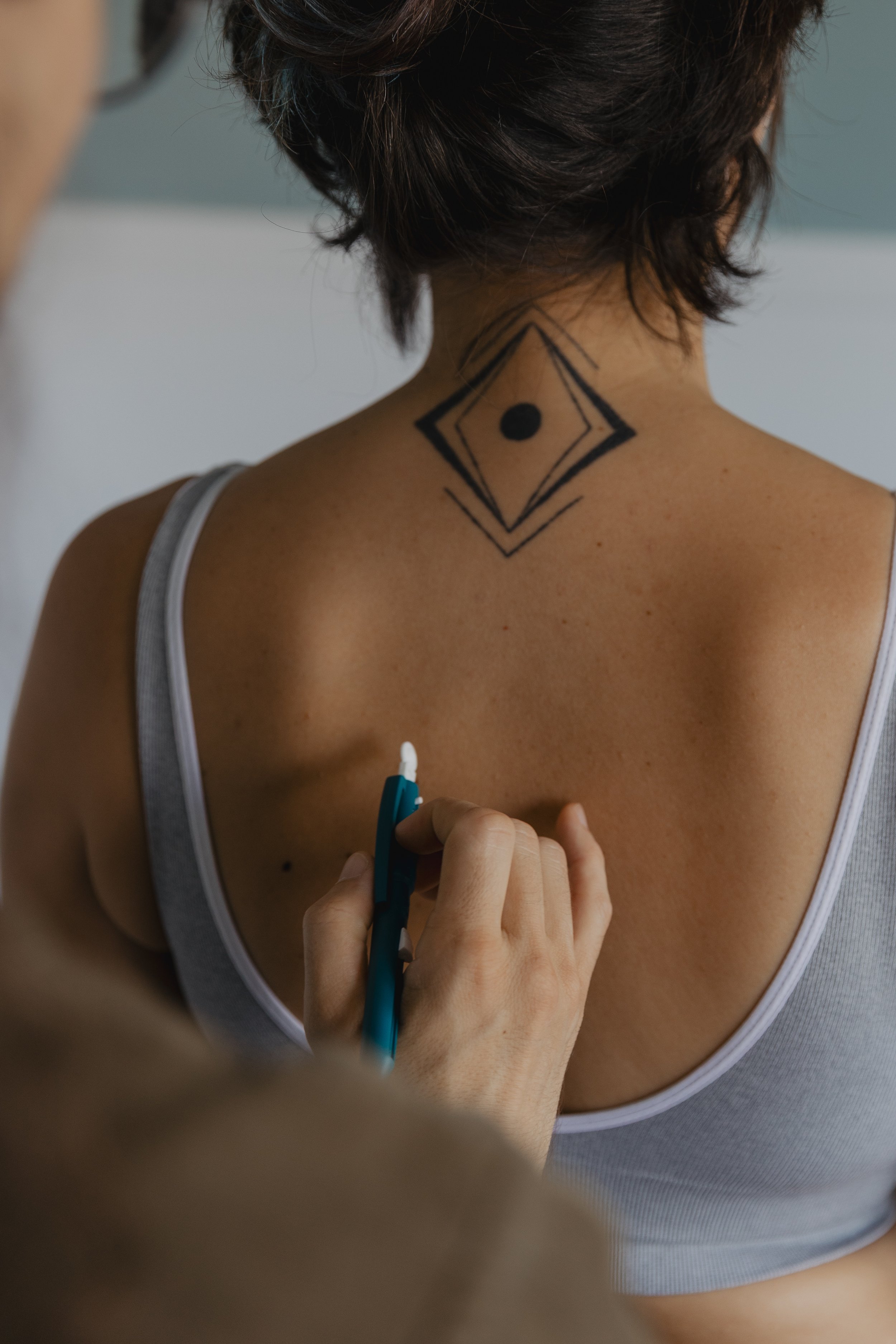 Kaspara Chaise demonstrating a type of sensory examination on a pain patient's back while they are standing.