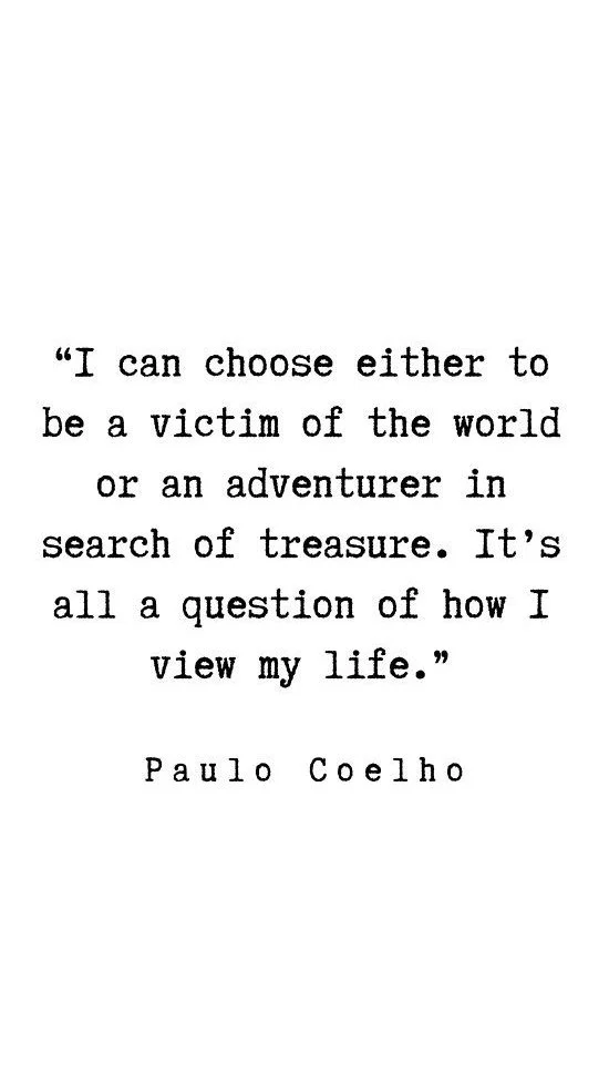 A quote by Paulo Coelho that reads, "I can choose either to be a victim of the world or an adventurer in search of treasure. It’s all a question of how I view my life." The quote is displayed on a white background in black, typewriter-style font.