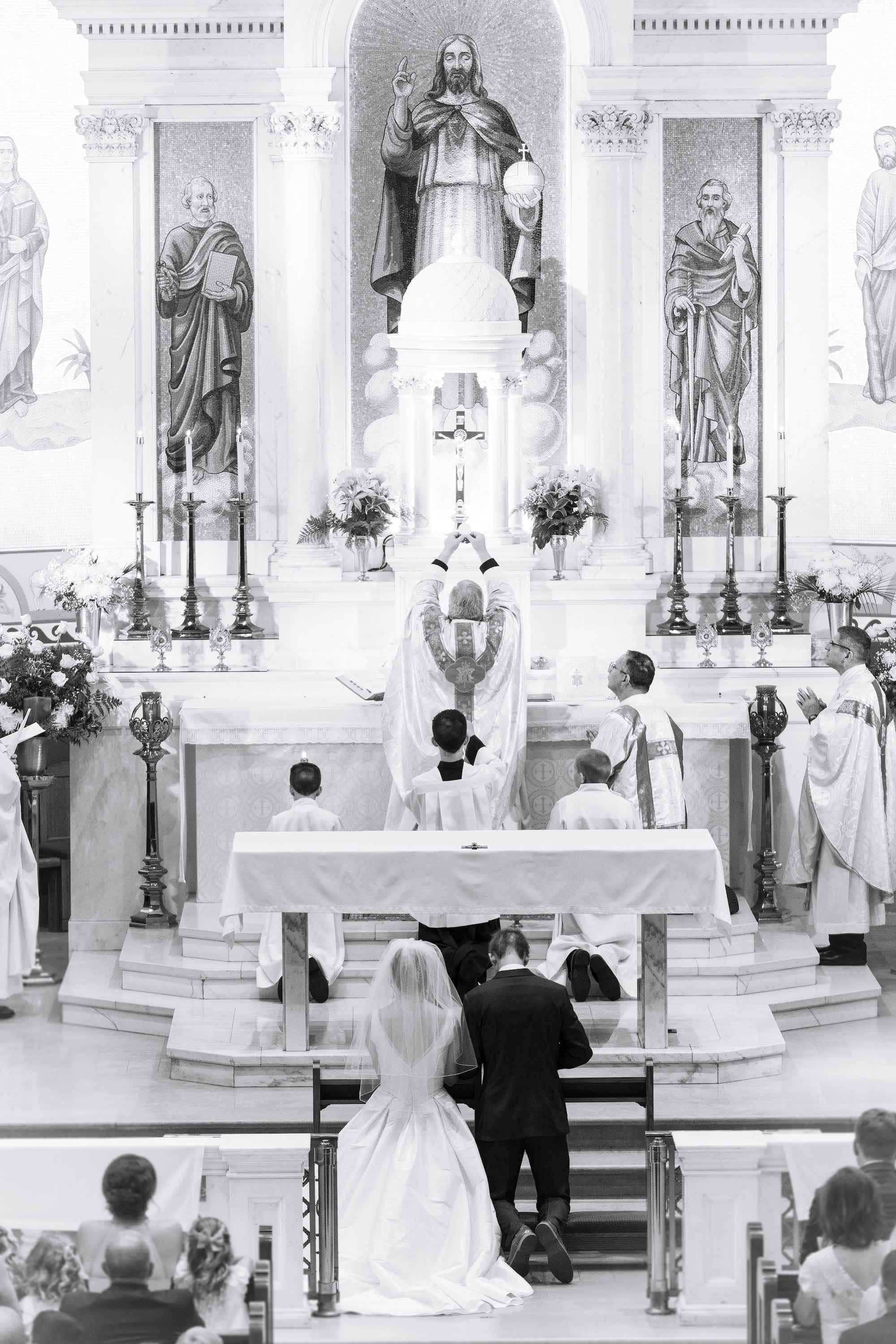 bride and groom kneeling at their wedding mass