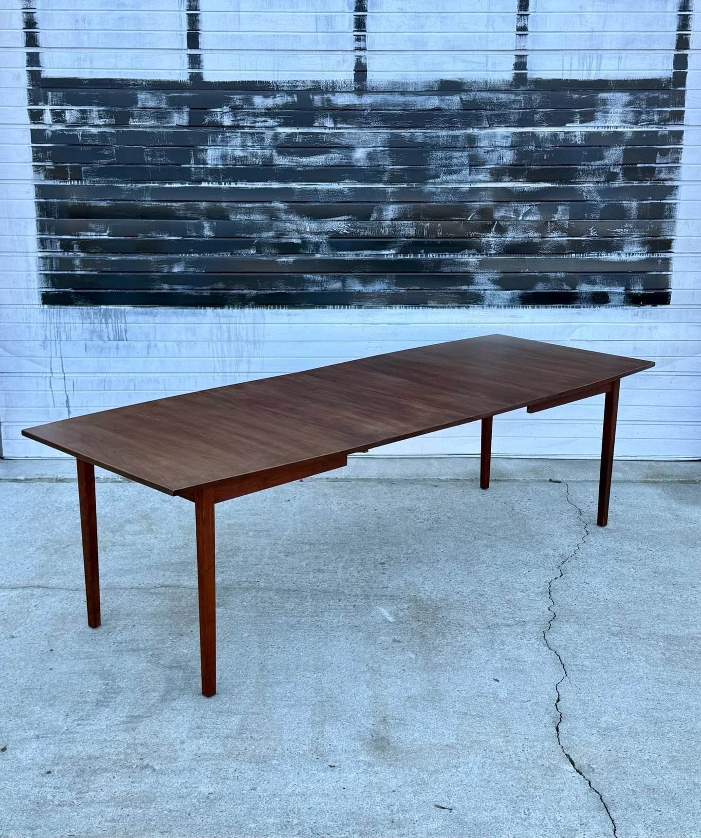 AVAILABLE ~ Mid-century dining table with two leaves by Founders. 

This table is made from warm walnut wood showcasing excellent woodgrain. Rectangular in shape with ends that taper to create a little more visual interest. Use with both leaves fully