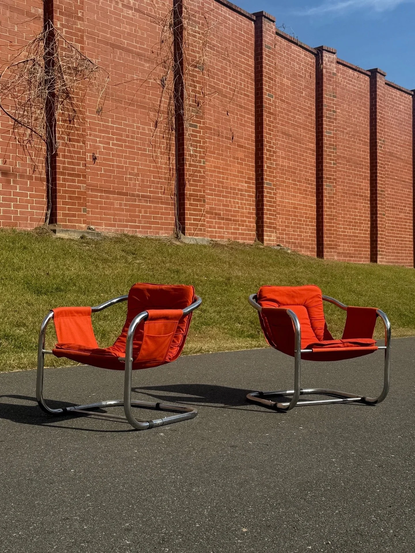 AVAILABLE ~ Postmodern pair of sling chairs in the style of Vecta Zermatt. 

This pair is made from tubular chrome frames. It gets its &ldquo;sling&rdquo; name from the upholstery that wraps around the slides of the frame. The fabric supports the use
