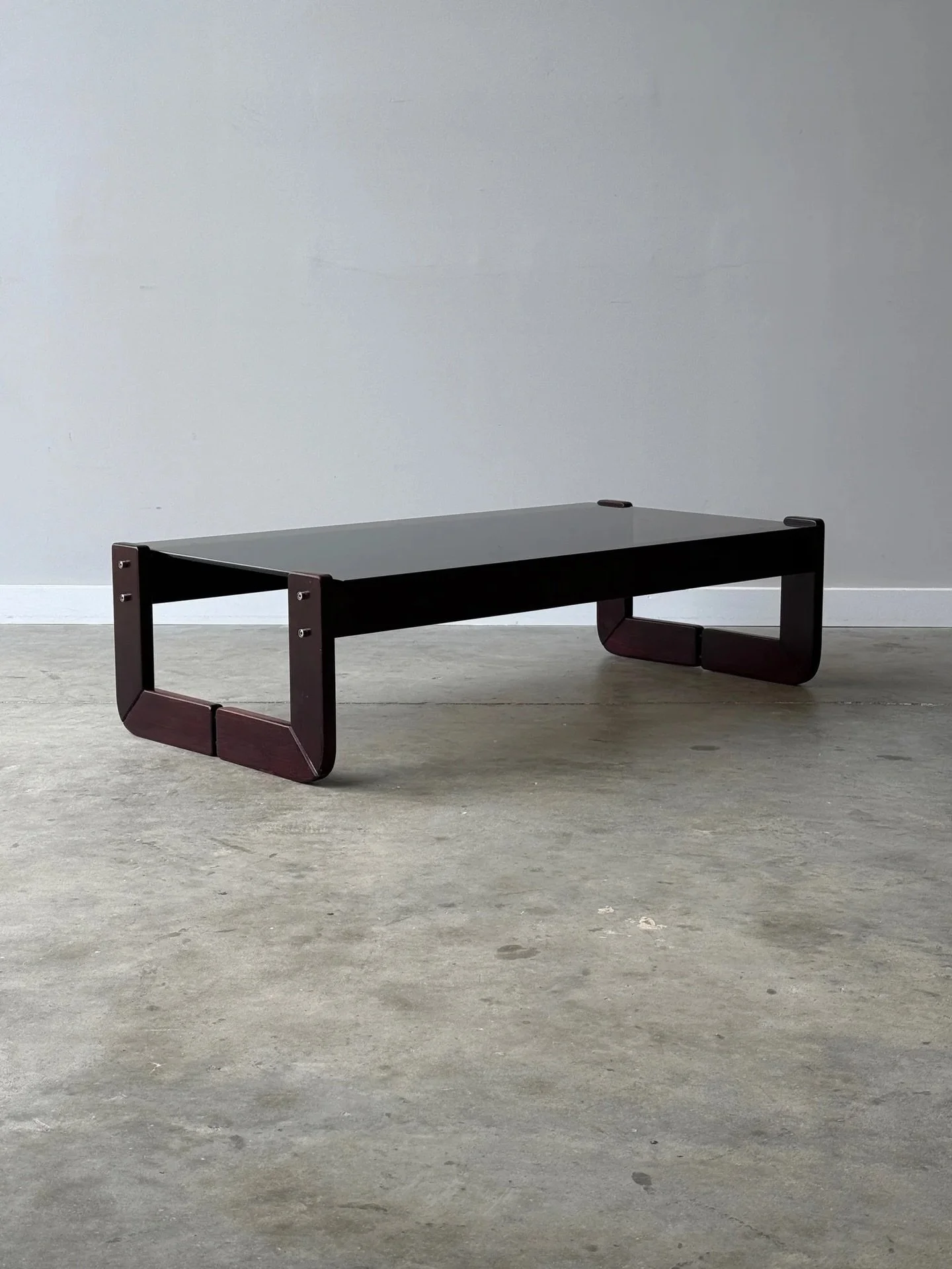 SOLD ~ Mid-century rectangular coffee table designed by Percival Lafer, circa 1970s. 

The base of the table is made from sculpted Brazilian rosewood. Rosewood known for being especially rich in saturation and grain. The two L-shaped legs conjoin tog