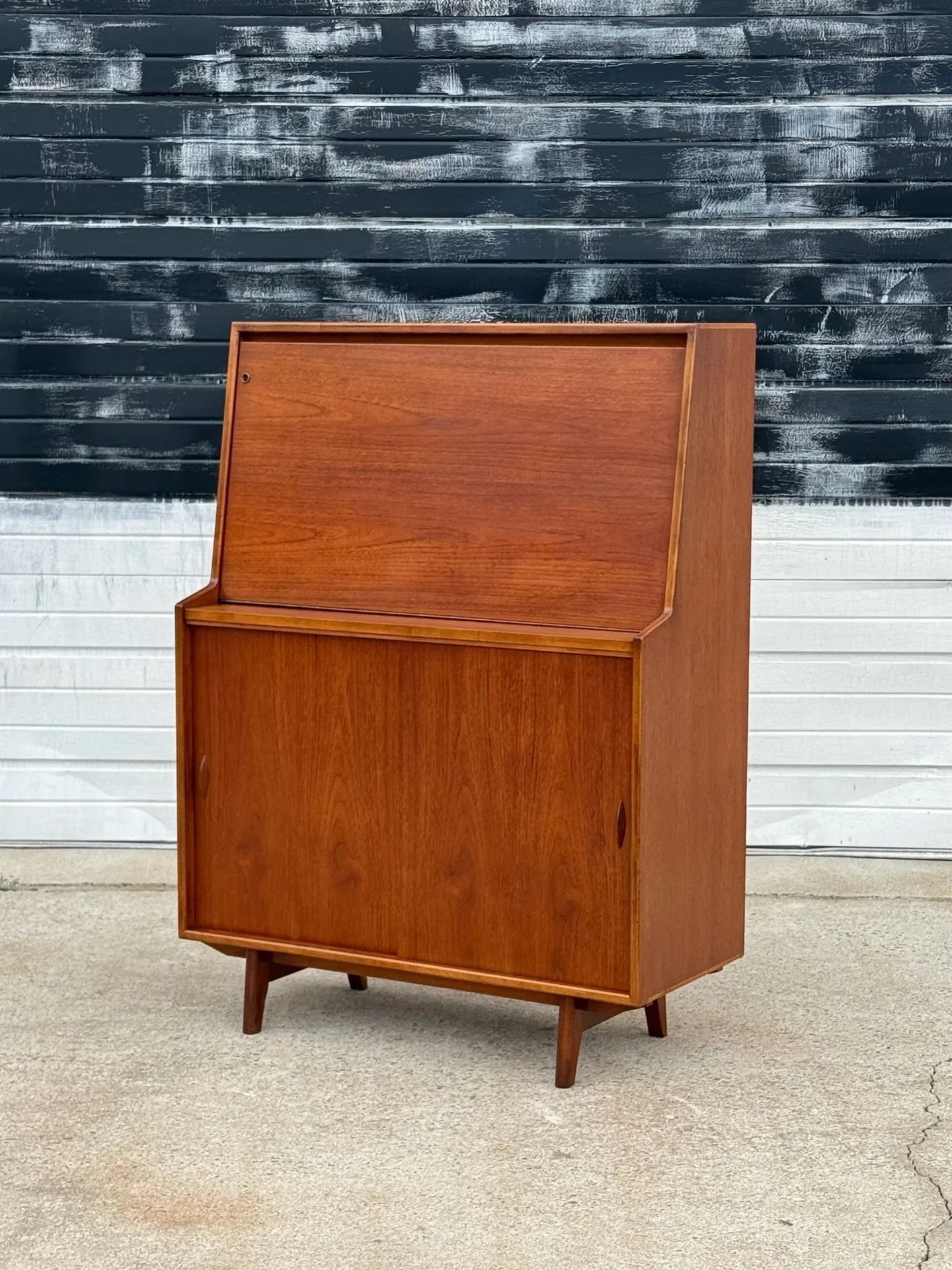 AVAILABLE ~ Mid-century slim teak bureau designed by Herbert Gibbs, circa 1960s. 

Manufactured in the UK and made from teak wood. Slim stature with a drop-down desk and cabinet storage below. Internal cubbies of varying sizes found within the top po