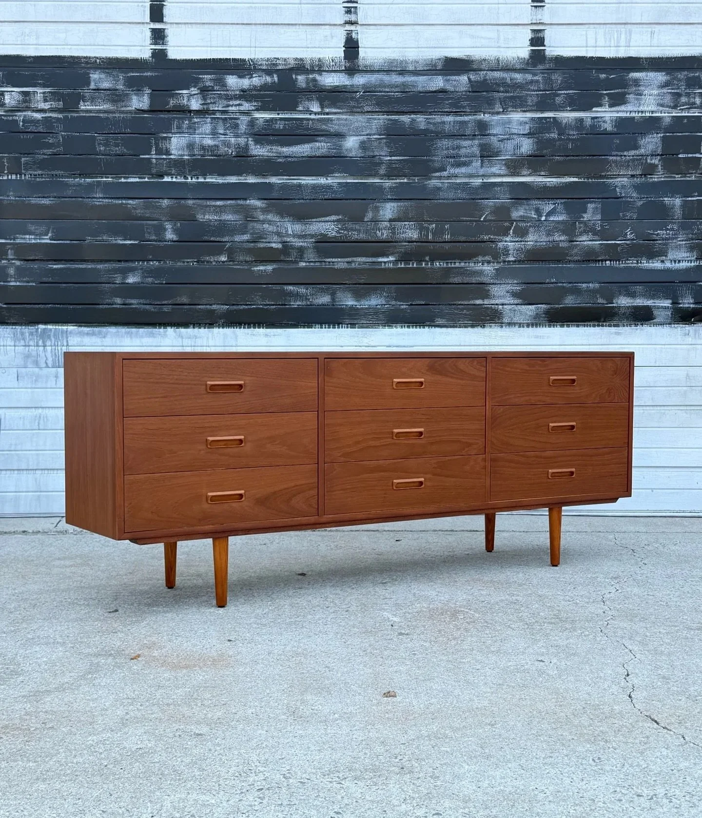 AVAILABLE ~ Mid-century nine drawer dresser made from teak wood, Denmark. Excellent teak grain throughout the entire piece. This long and low dresser features a bank of three drawers on the left, right, and middle section. Each drawer is deep and spa