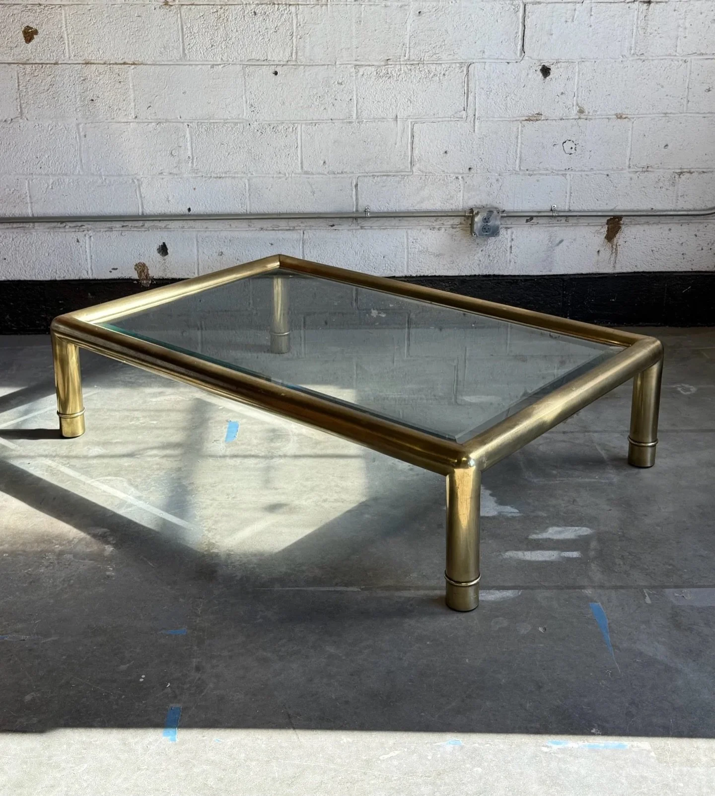 AVAILABLE ~ A beautiful vintage XL rectangular coffee table by Mastercraft, circa 1970s. 

The brass is tubular and the glass is set inside pronouncing a large transparency of surface area.  Wonderfully aged patina and perfectly in vogue.  No chips o