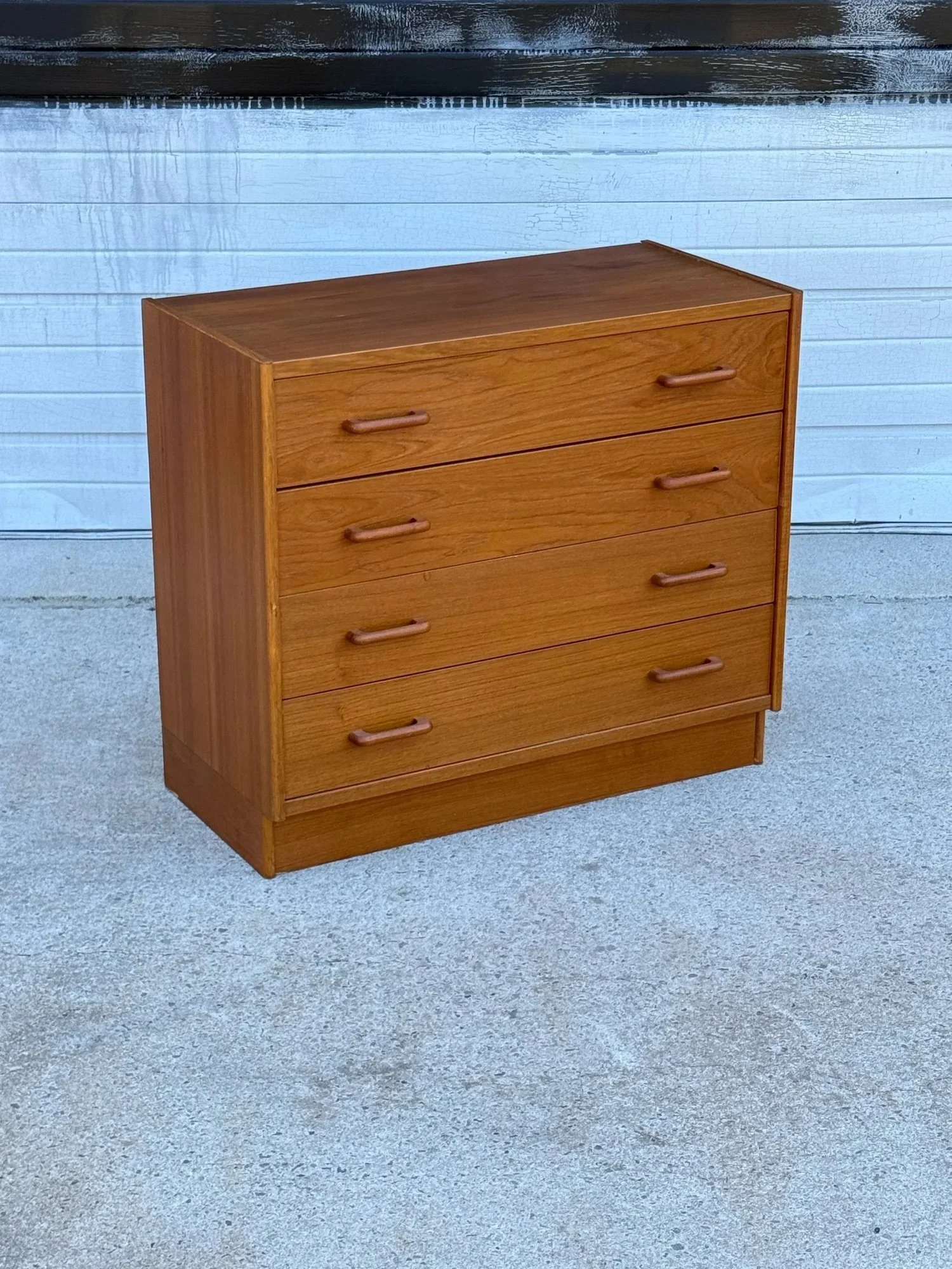 AVAILABLE ~ Small mid-century chest of drawers. Made from teak wood, Denmark. Excellent woodgrain throughout the piece. Compact design and featuring a bank of four spacious drawers.

Each drawer is equipped with two carved teak handles. The handles a