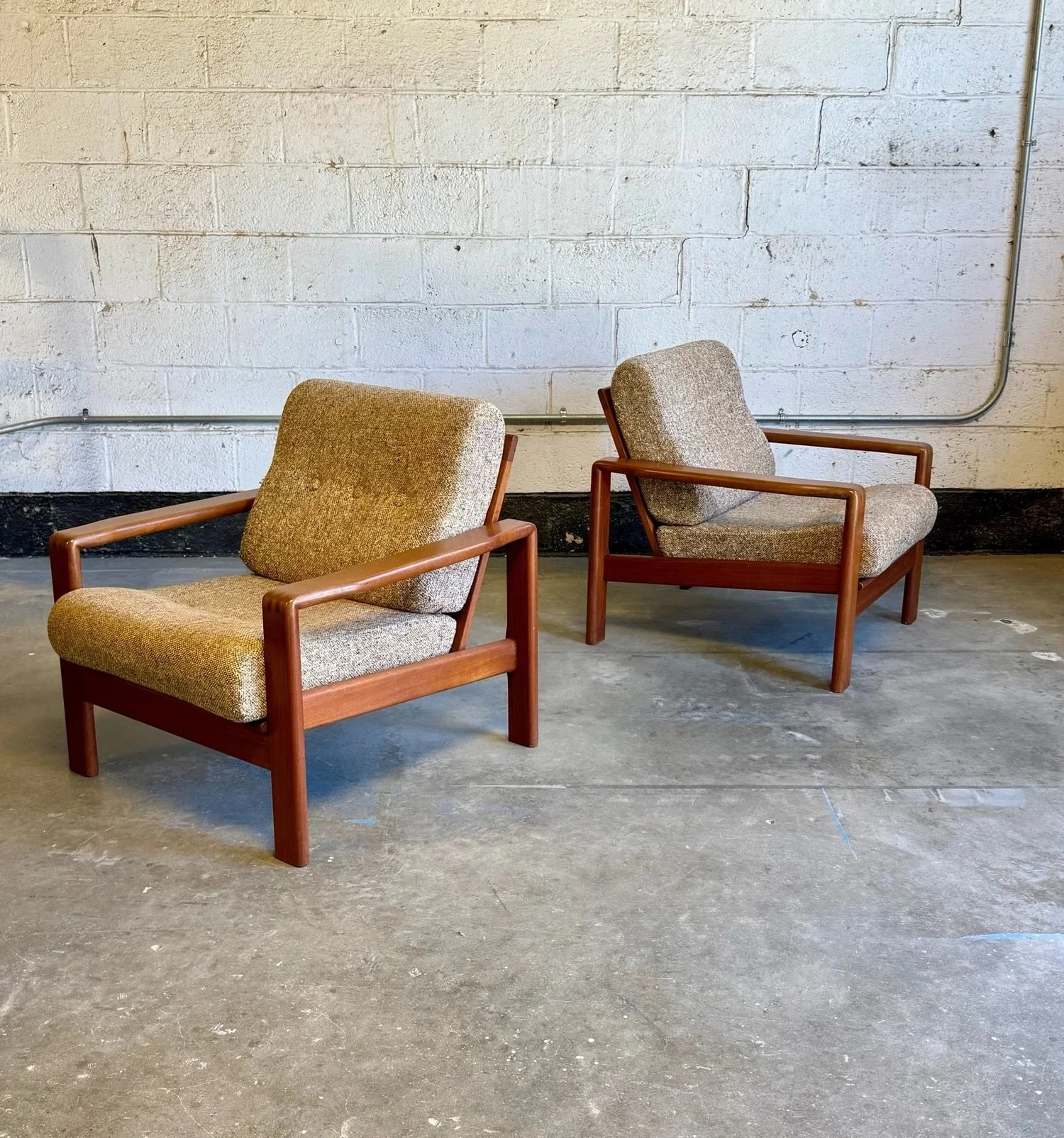 AVAILABLE ~ Mid-century lounge chairs, made in Denmark. In the stylings of H.W. Klein for Bramin M&oslash;bler. 

Hefty and sturdy teak frames. The legs are squared and integrate into armrests. Slat back design that perfectly showcases the fabric und