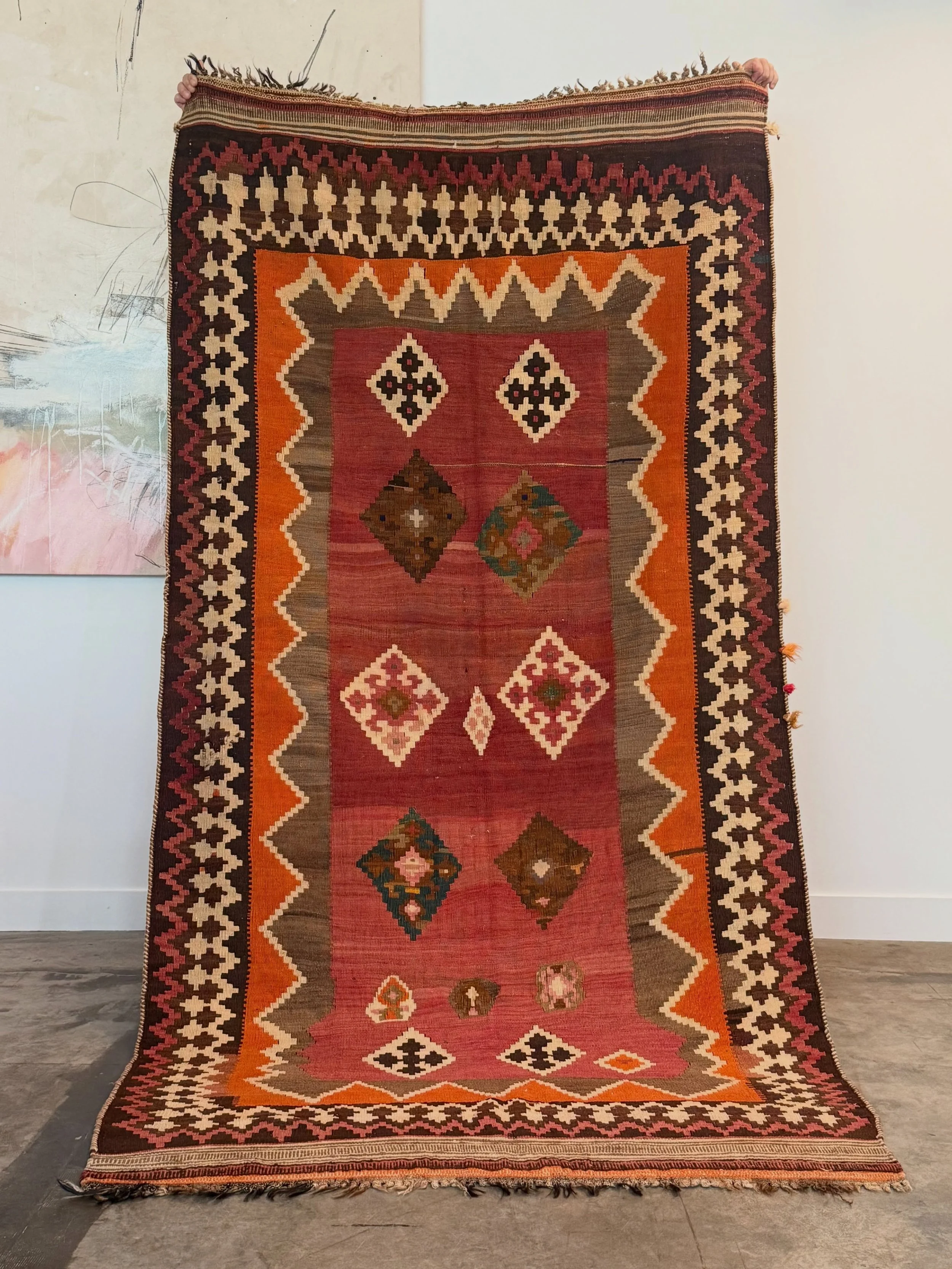 AVAILABLE ~ Antique kilim rug. Vibrant earthy colors of brown, orange, and terracotta. 

Geometric borders and diamond motif with various patterns in the center. The ends of the rug have a little bit of fringe. In overall great vintage condition with