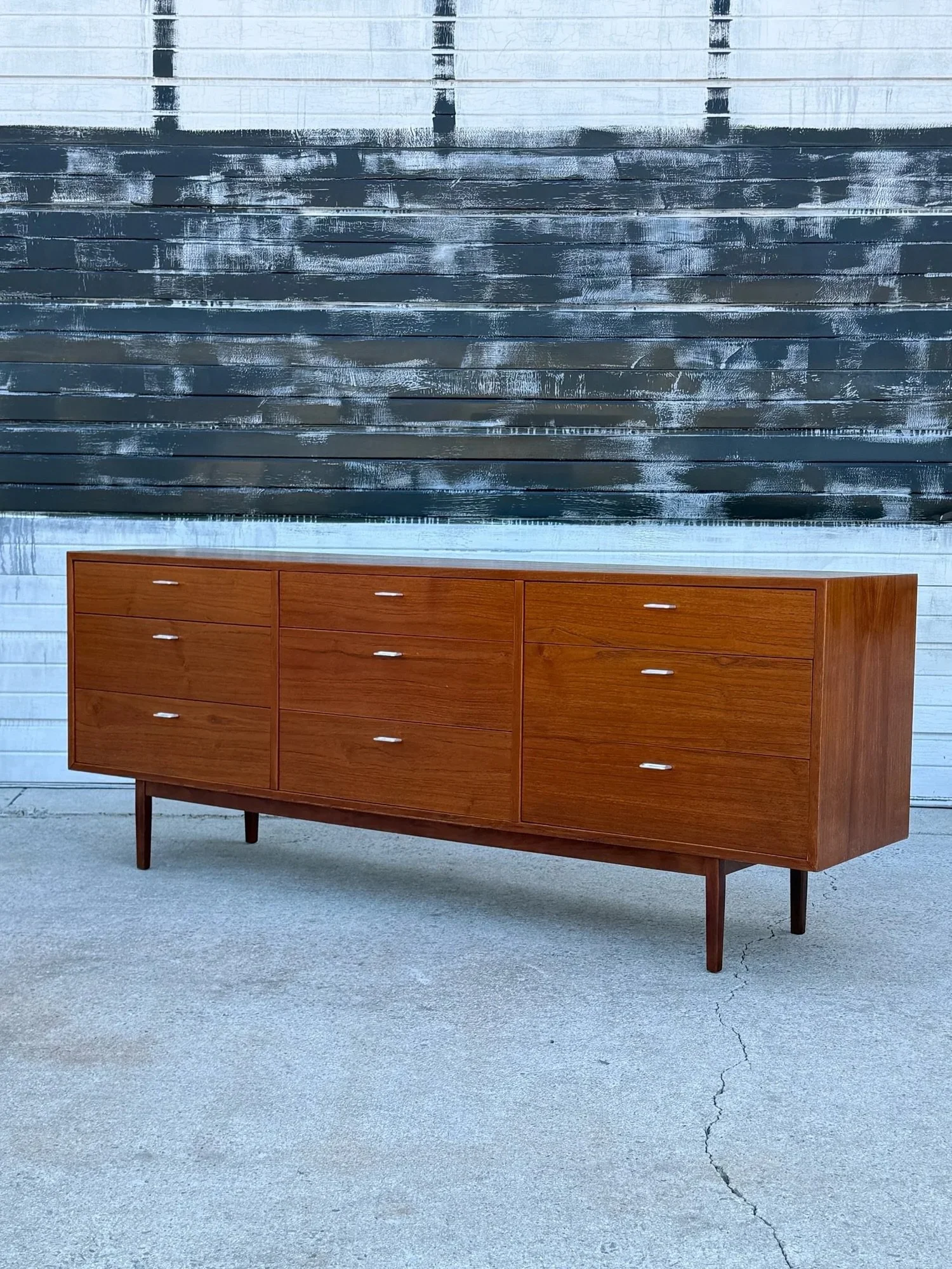 AVAILABLE ~ Mid-century nine drawer dresser. Made from teak wood, Denmark. This long dresser features warm rich wood tone and ample storage potential. 

The middle, left, and right-hand side each have a bank of three drawers - nine total. Each drawer