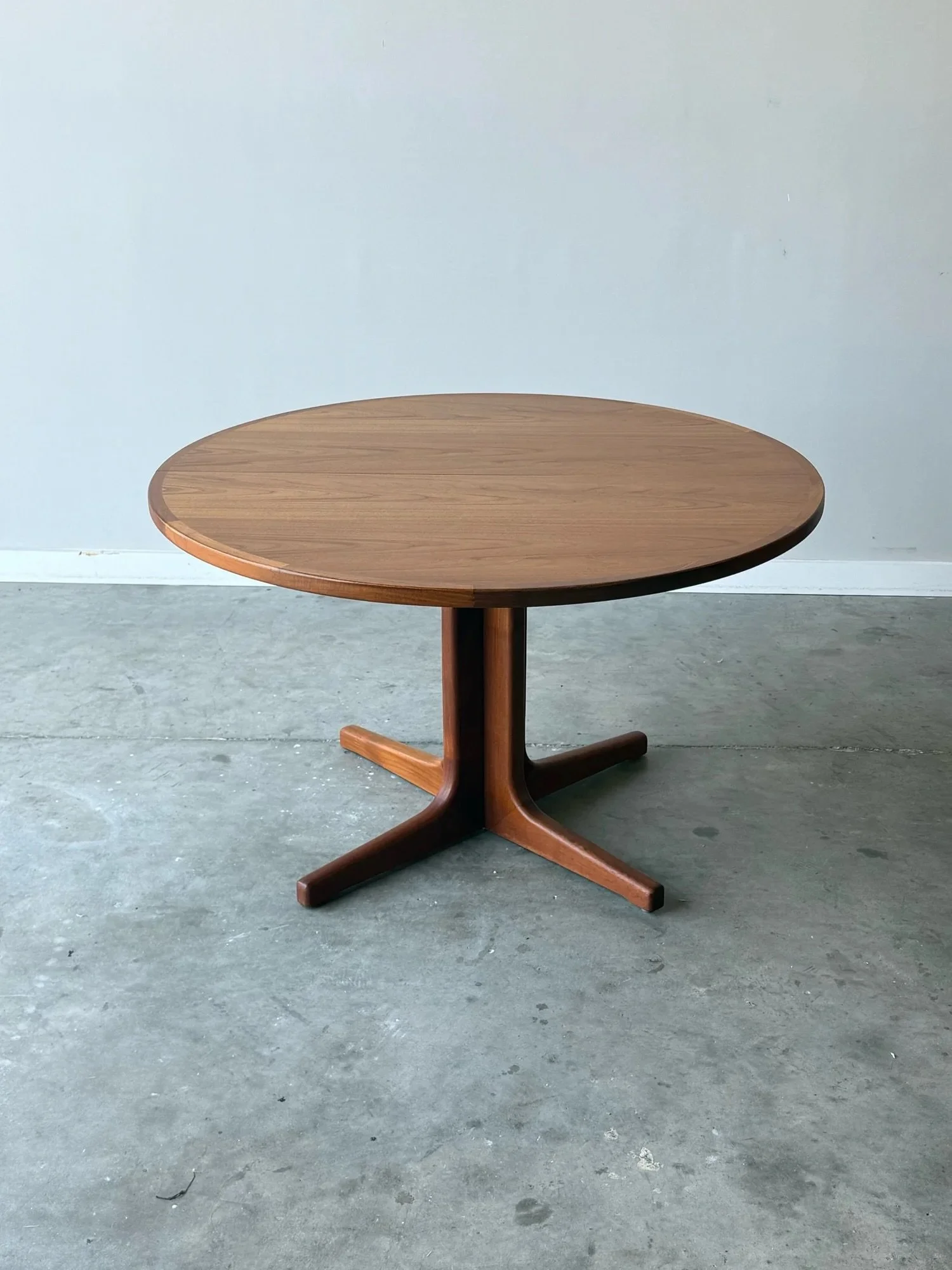 AVAILABLE ~ Mid-century expanding dining table with two leaves. 

Made in Denmark from teak wood. Without any extensions, the table forms a perfect circle. As one leaf or both leaves are added, the table becomes oval in shape. The depth of this table