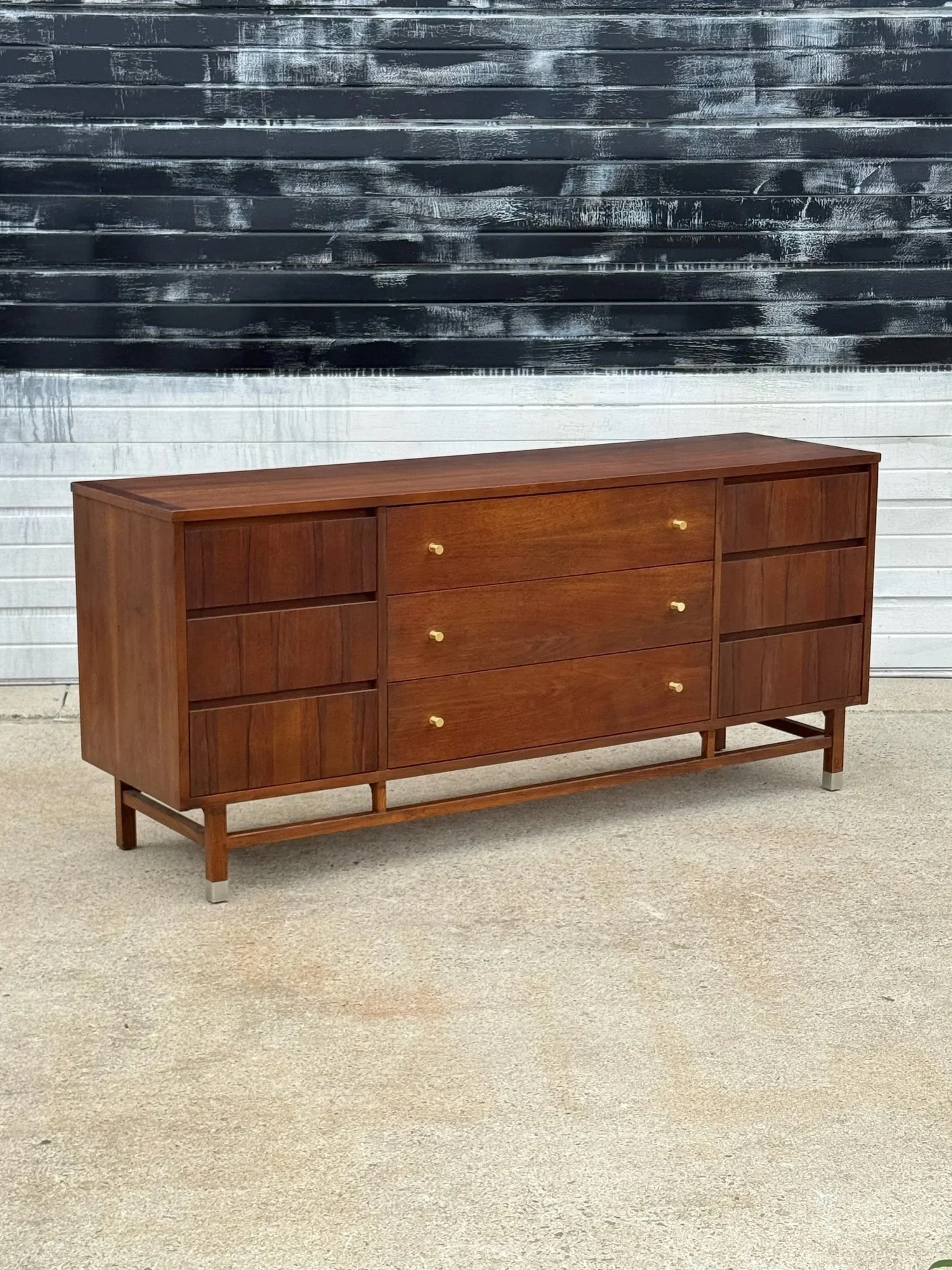 AVAILABLE ~ Mid-century dresser manufactured by Stanley. This piece is crafted from walnut wood with rosewood accents. The mix of wood species and grain throughout is fantastic. 

Featuring a total of nine drawers. Each side has a bank of three small