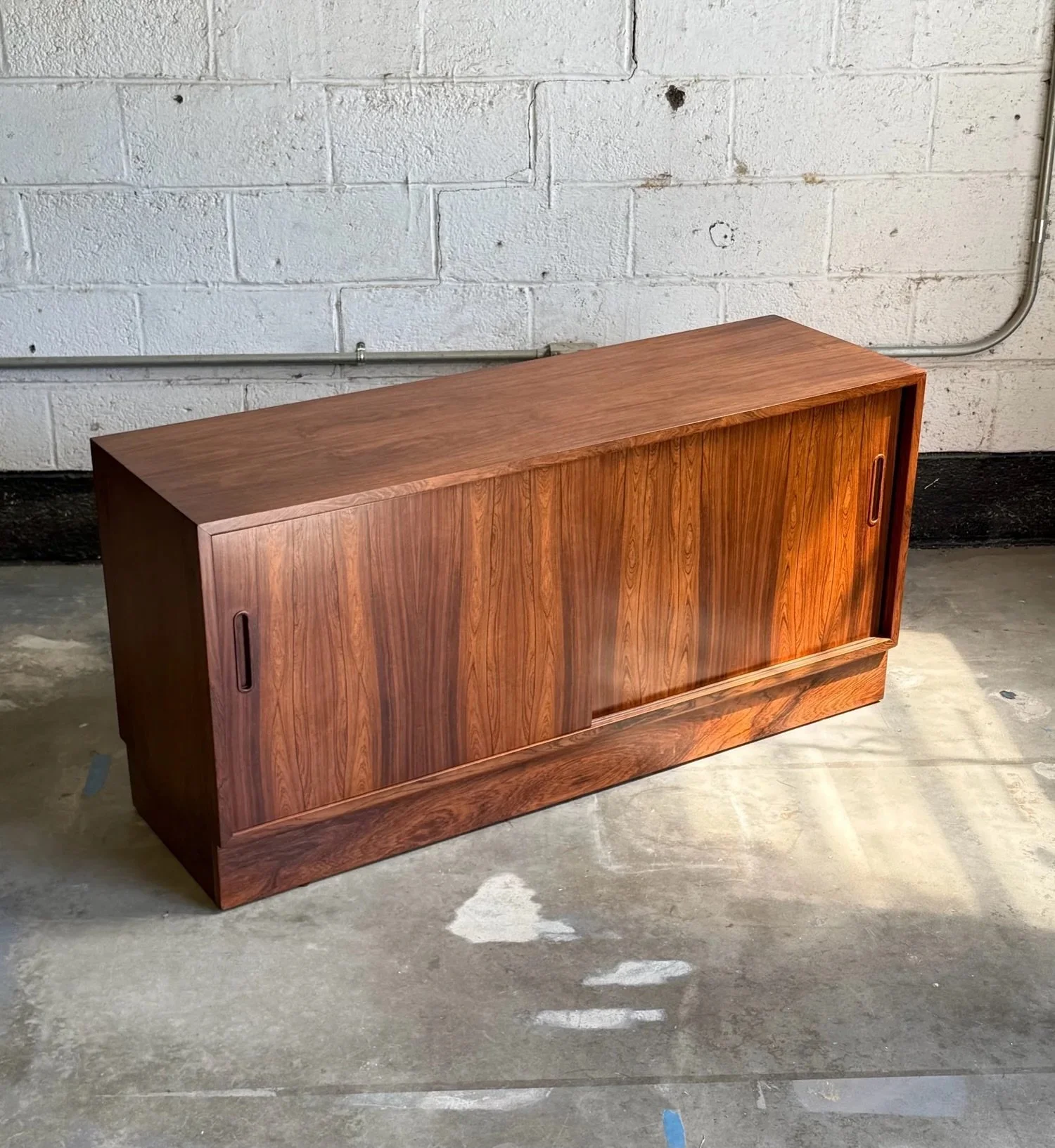 AVAILABLE ~ Mid-century credenza by Poul Hundevad, Denmark circa 1960s. A smaller scale credenza perfect for compact spaces.

Crafted from rosewood which has a deep brown color and incredible woodgrain. This piece features two sliding doors. Each doo