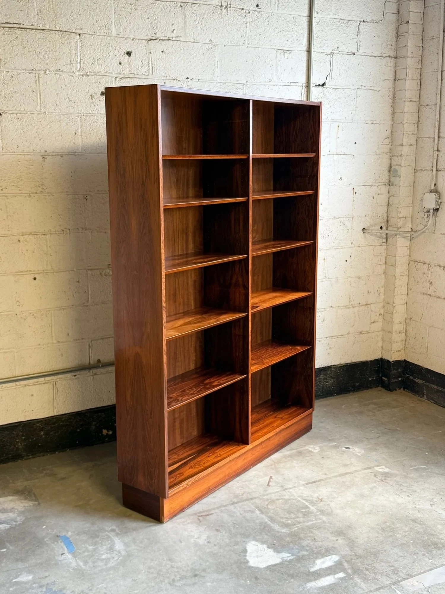 AVAILABLE ~ Mid-century double bookcase made from rosewood by Poul Hundevad and manufactured in Denmark, circa 1960s. 

Tall double bookcase design featuring ten total shelves. Eight shelves are adjustable or completely removable. The entire bookcase