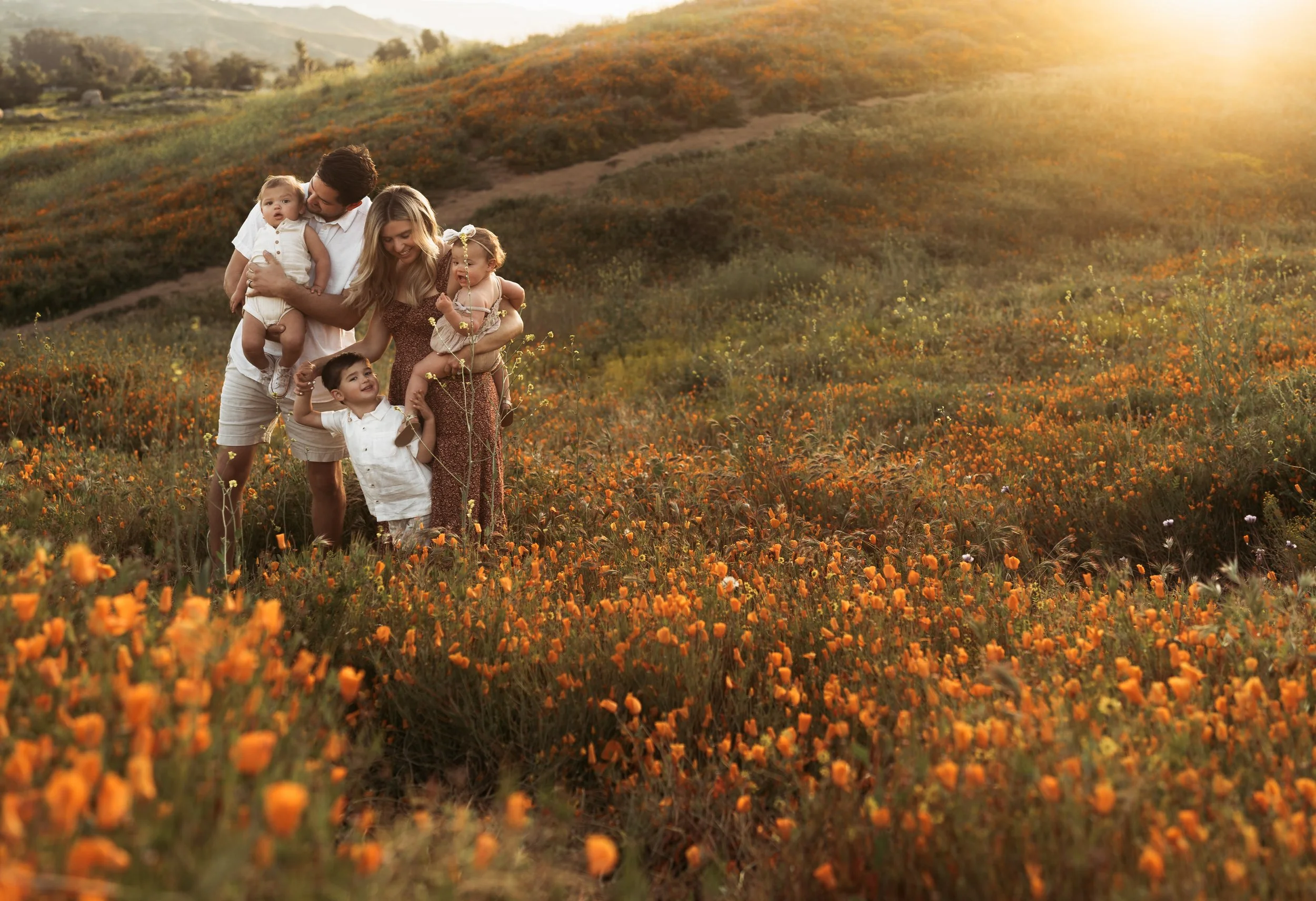 Southern California family photographer captures family in a poppy covered field at sunset in riverside California.