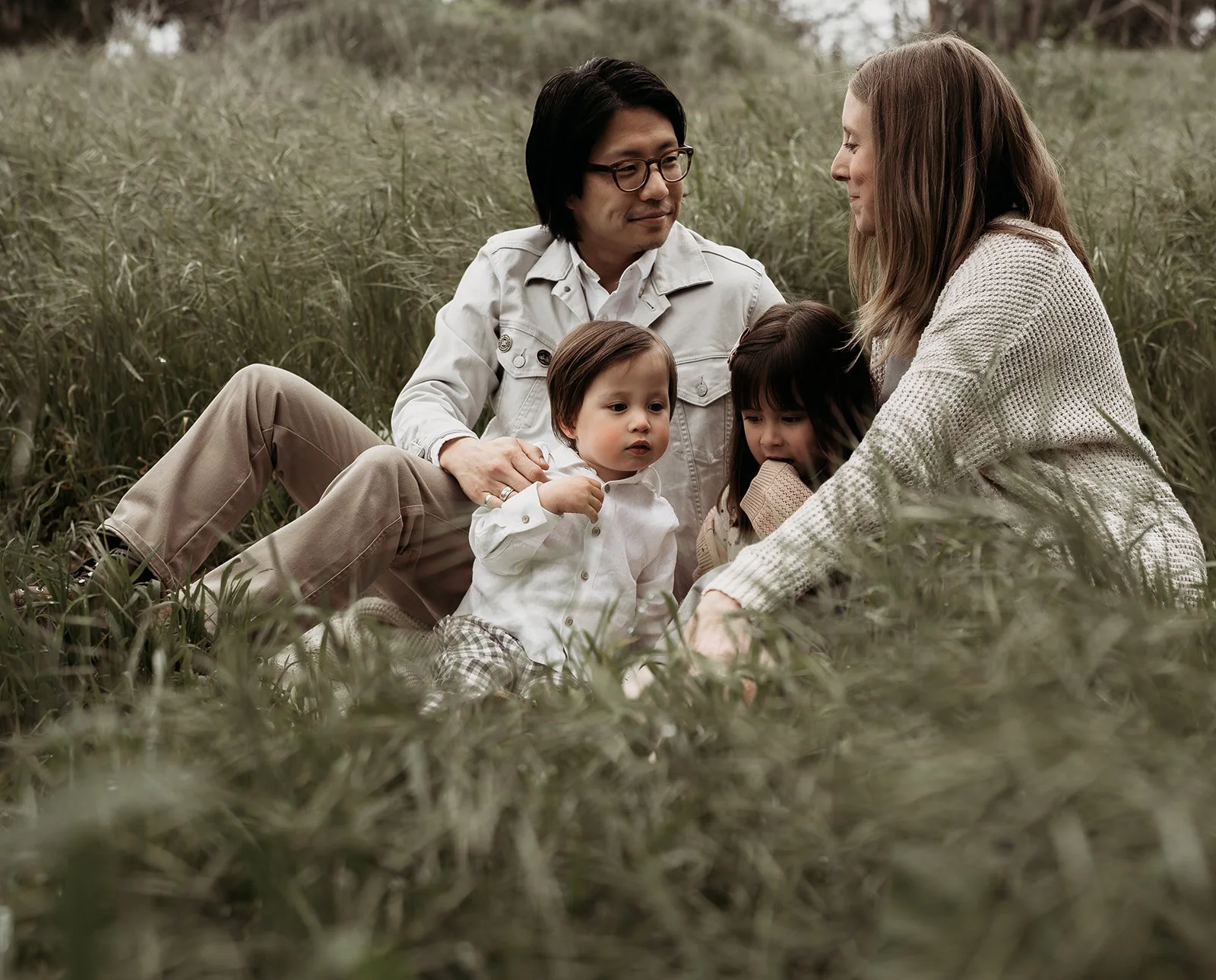 Southern California family photographer captures family in the grassy hills at Frog Creek Park near Long Beach California.