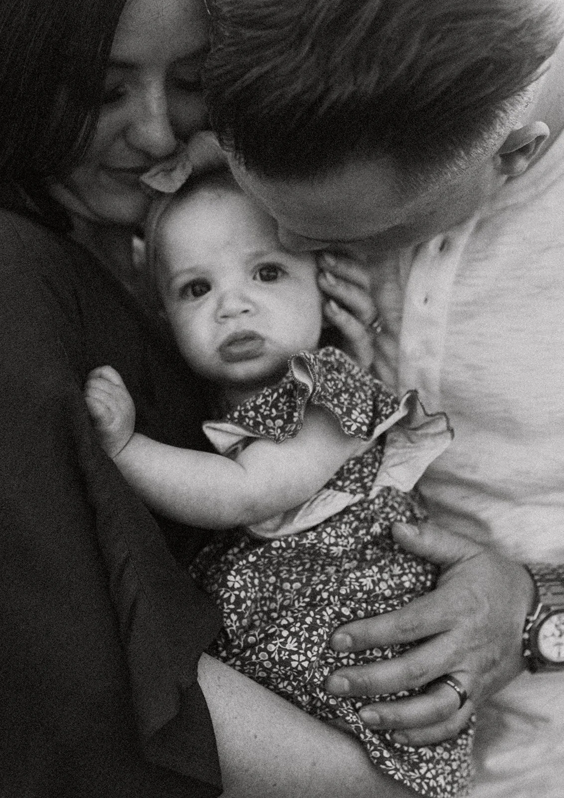 Southern California family photographer captures a detail shot of mom and dad snuggling the baby in a sunset shot in sycamore creek park in riverside California