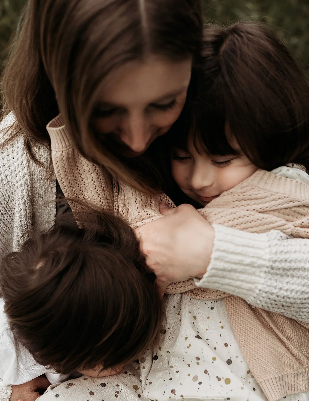 Southern California photographer captures mother snuggling her two children at frog creek park in Long Beach California.
