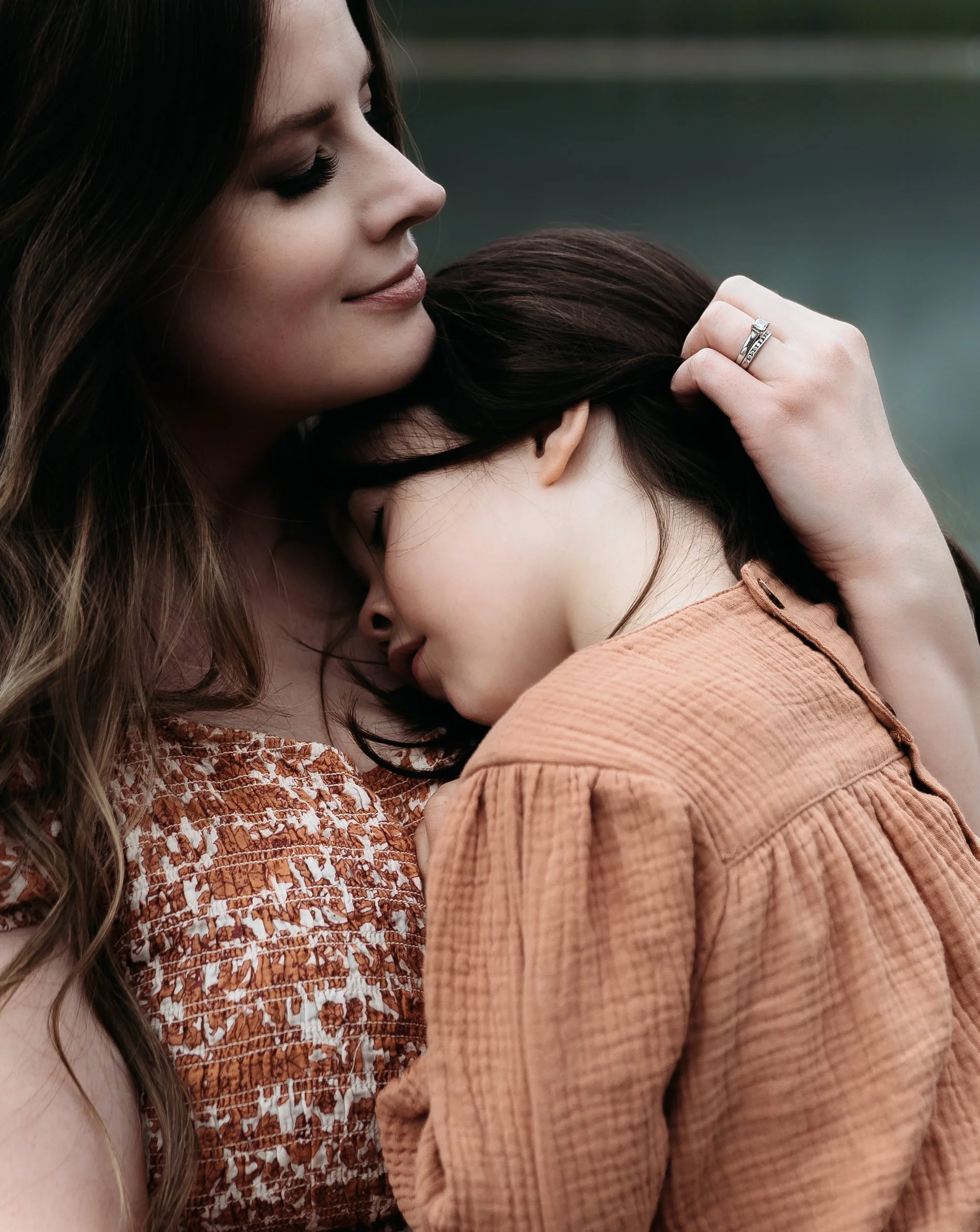 Banff national park family photographer captures family near Canmore alberta. mother runs fingers through daughters hair