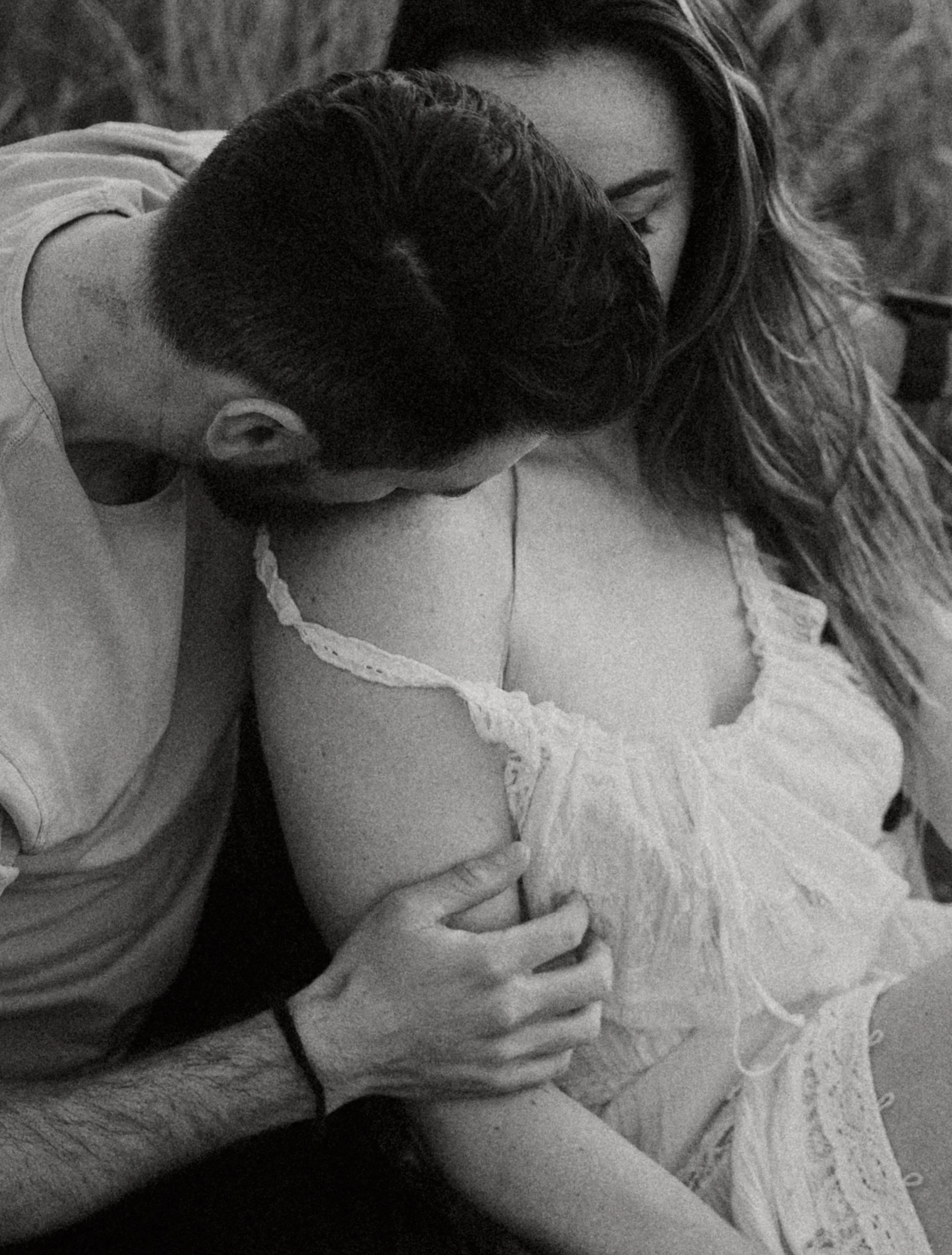 grand Teton national park elopement photographer captures couple near Schwabacher's Landing snuggling with the Teton's in the background. Bride is wearing a white dress and groom is wearing tan bylt shirt in this moody, rich edit.