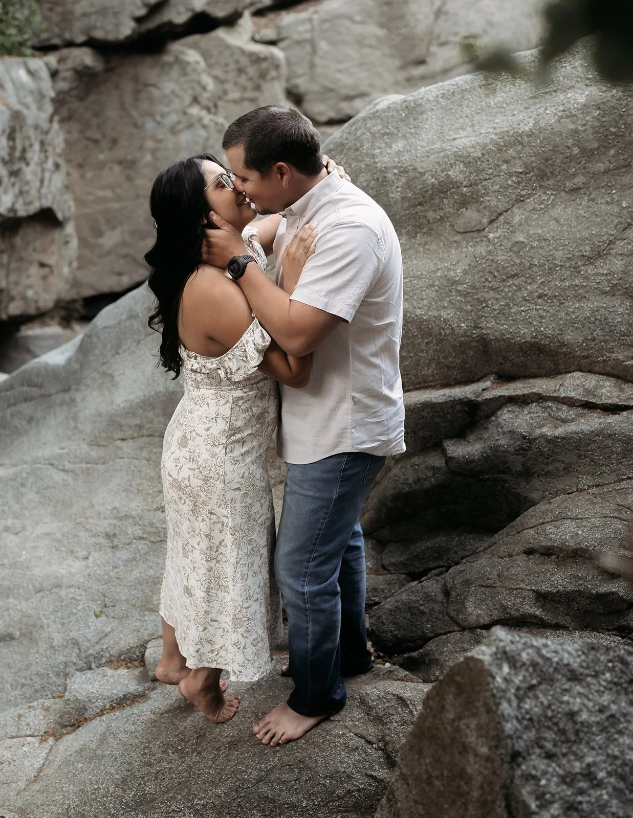 Southern California elopement photographer captures bride and groom kissing at the top of heart rock trail in crestline California. this moody, rich edit takes place at the top of the rocks near big bear lake