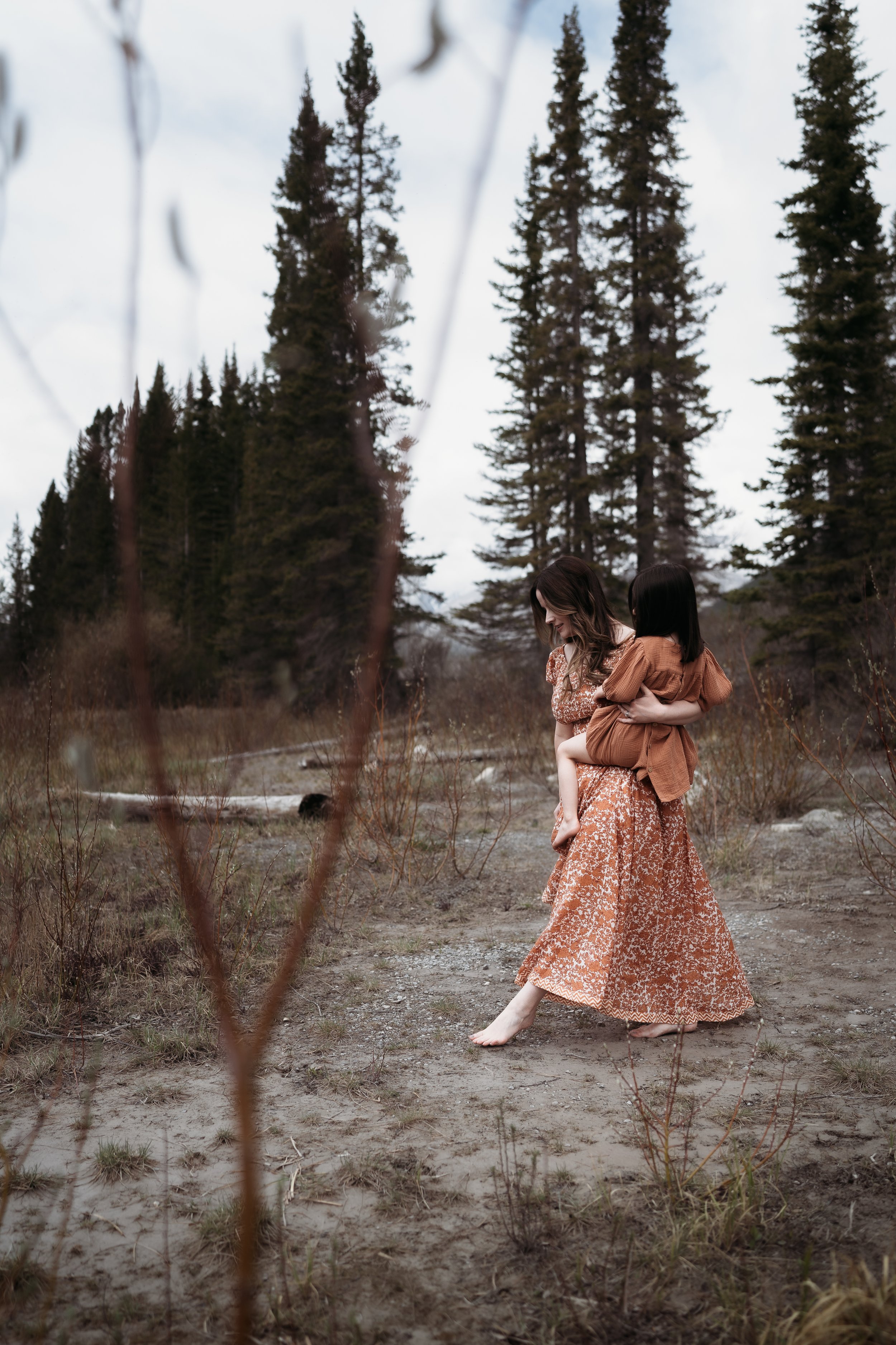Banff family photographer captures mother and daughter walking down to the lake in Canmore AB.