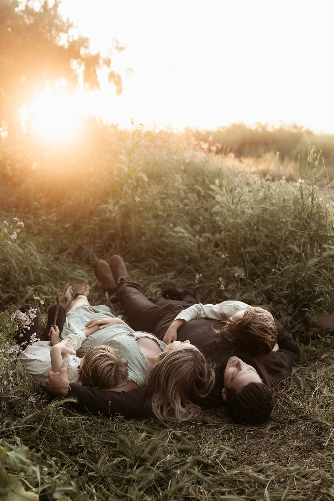 Southern California family photographer captures family laying in the wildflowers in gum grove park near Long Beach California at sunset