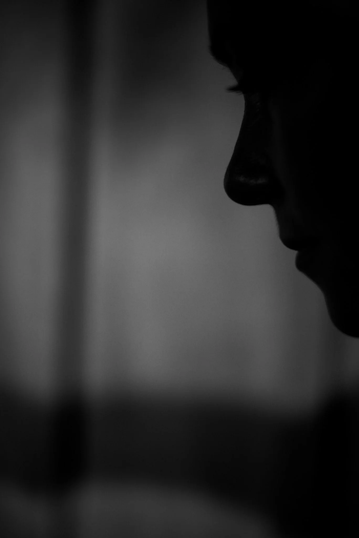 Close-up silhouette of a person's profile in low lighting