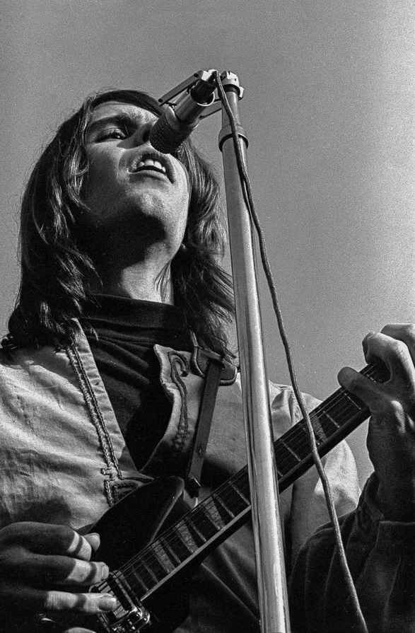 A man playing guitar and singing into a microphone