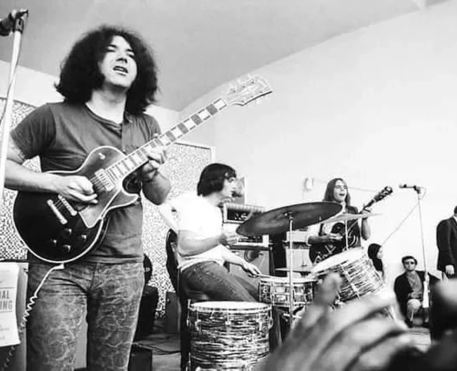 Two guitarists and a drummer playing a concert