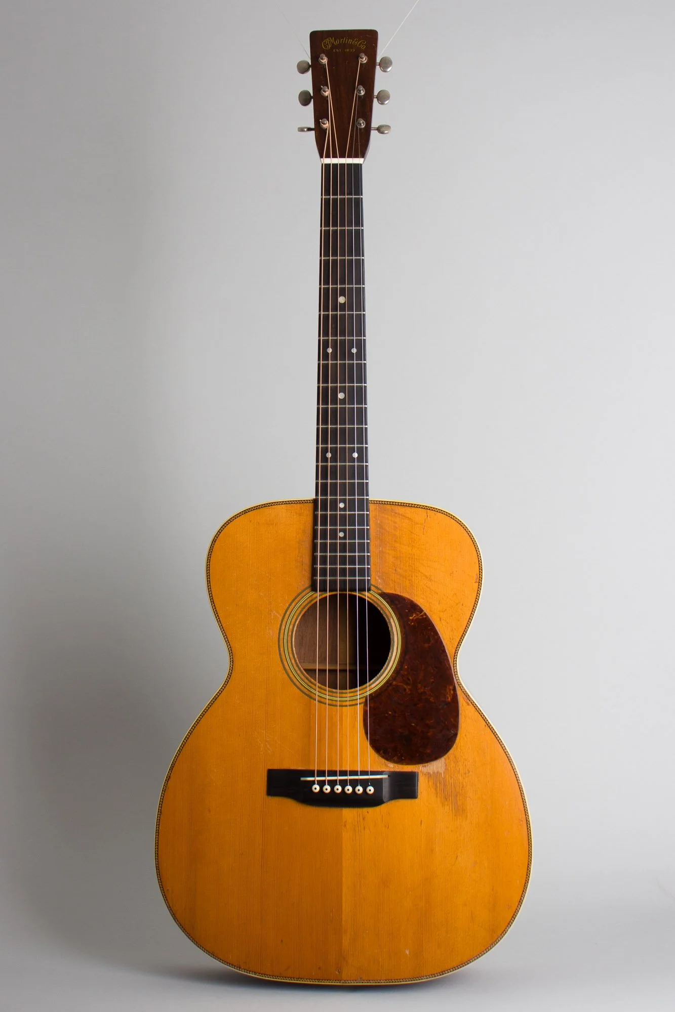 A concert-shaped acoustic guitar with a light wood finish