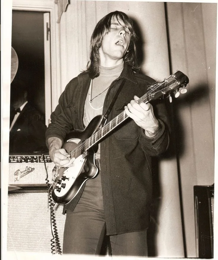 A man playing guitar with his eyes closed, feeling the music