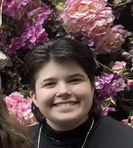 a person smiling in front of flowers