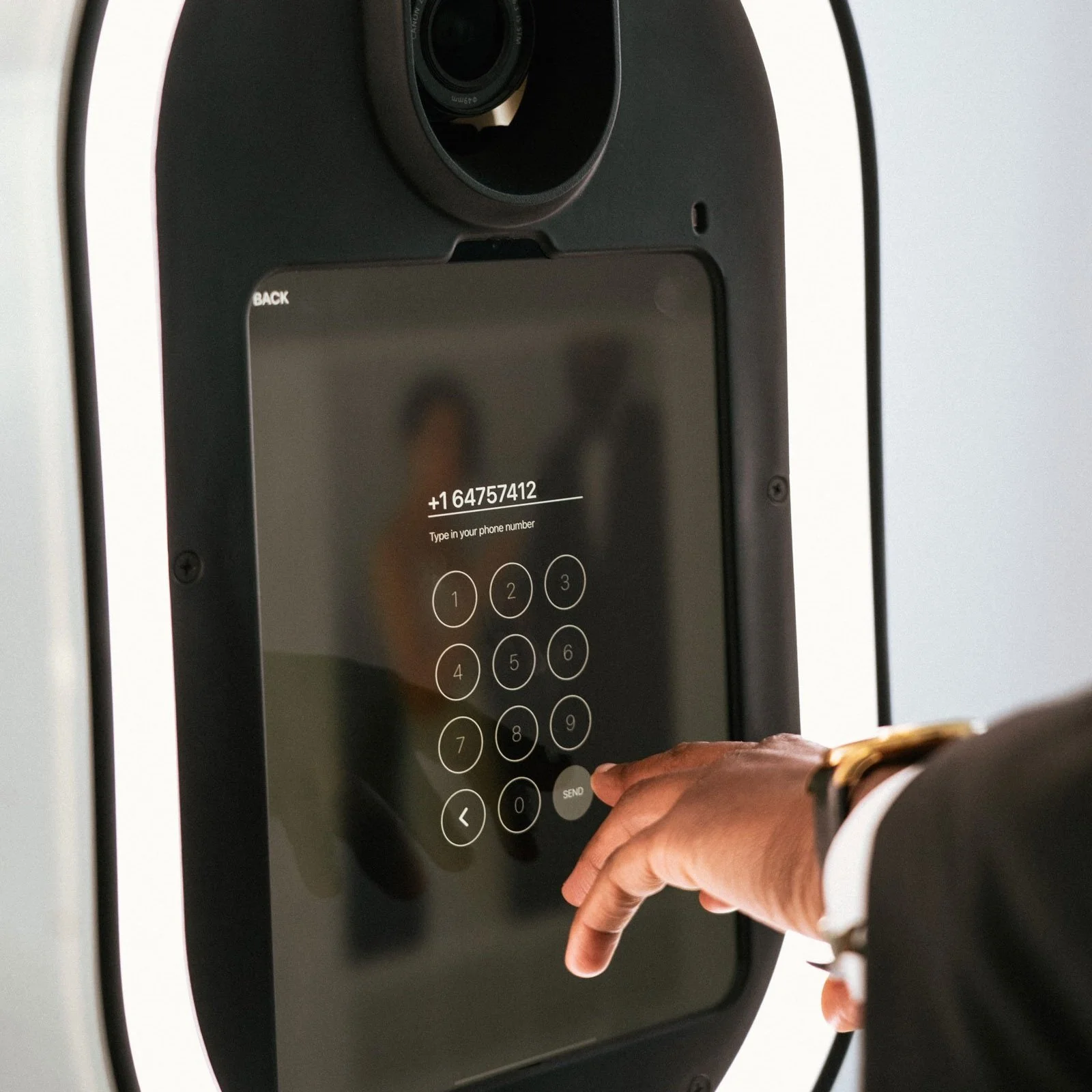 Person inputting their phone number on a photo booth interface
